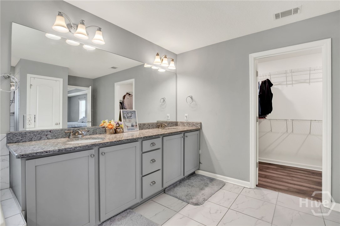Primary Ensuite with Double Vanity, Walk-In Closet, and Under-Cabinet Lighting