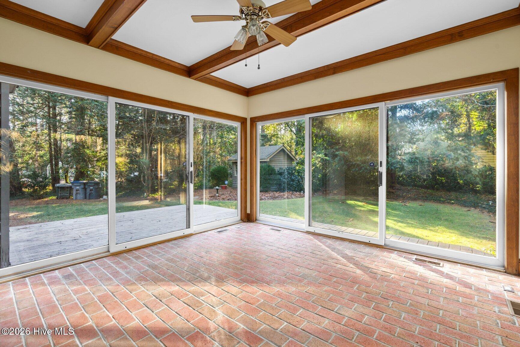 Sunroom allows access to the large rear deck perfect for grilling or relaxing .