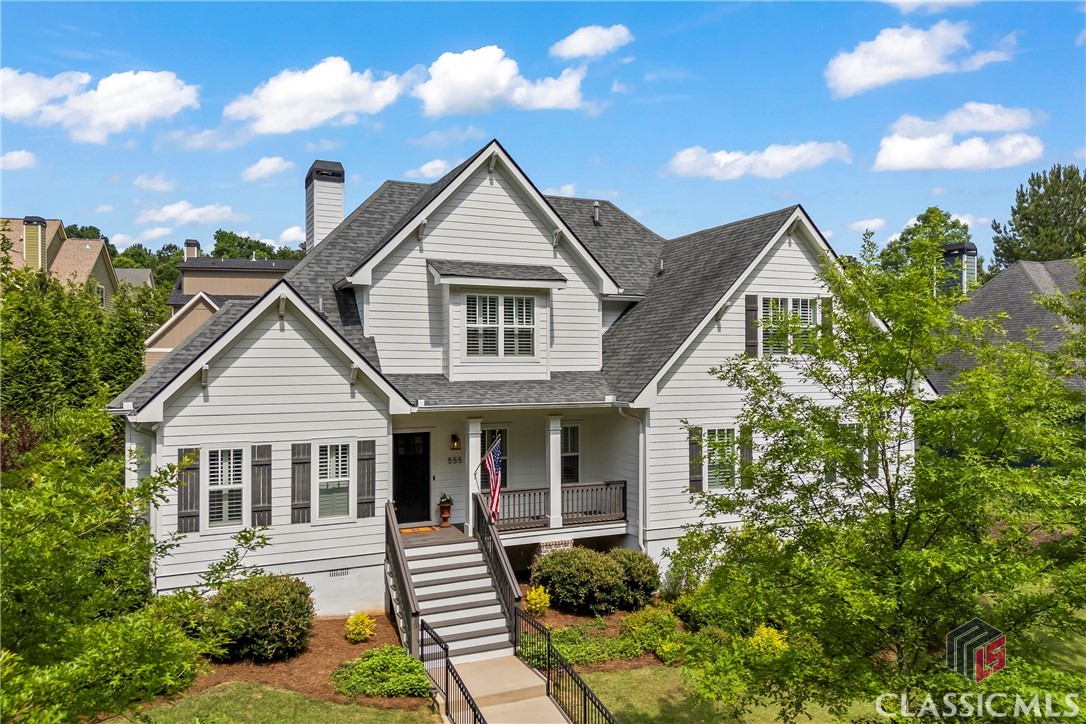 Once featured in Athens Magazine, HGTV Magazine, and Better Homes and Gardens, boasting pure elegance and natural light. This 3,305 sq ft home is beautifully accentuated by soaring 10-foot ceilings.
The spacious dining room welcomes guests just right of the entrance, comfortably accommodating 8-10 people with room for display furniture. This entertaining space transitions seamlessly into the gourmet kitchen featuring a gas cooktop, quartzite countertops, central island, farm sink, and floating shelves. An amazing butler's pantry sits adjacent to the shelving.

The family room features a coffered ceiling and a wood-burning fireplace that offers warmth and coziness. French doors illuminate the space and provide access to the patio and professionally landscaped backyard.

The owner's suite serves as a peaceful retreat with French doors leading to a covered patio section. The bathroom showcases a soaking tub, expansive tiled shower with frameless glass, and double vanity with abundant storage. The designer selected white quartzite countertops, white subway tile shower surrounds, and gray tile flooring—a timeless palette repeated throughout all bathrooms. The shared closet offers generous space for all wardrobe needs.

A powder room and laundry/mud room with organizational features for family essentials complete the main floor. Upstairs hosts four bedrooms, including one with a private bath, plus a hall bathroom featuring a double vanity and tile surrounds.

Two versatile bonus spaces enhance the home—the main floor flex room with French doors perfect for entertainment or work, and an upstairs space with built-in desks and window seating ideal for various purposes.