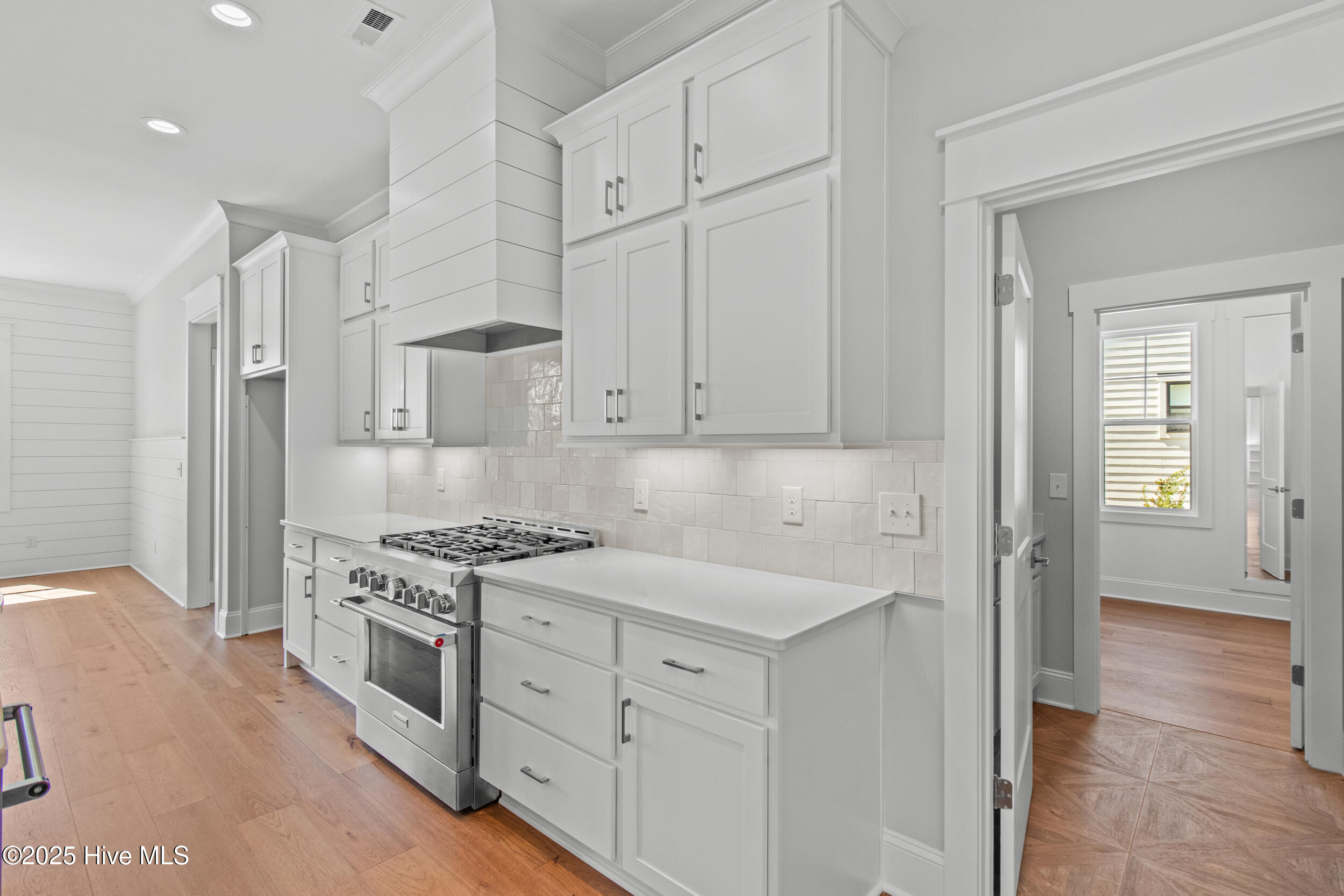 6-burner natural gas cooktop with framed hood, porcelain farm sink, and beautiful hardware