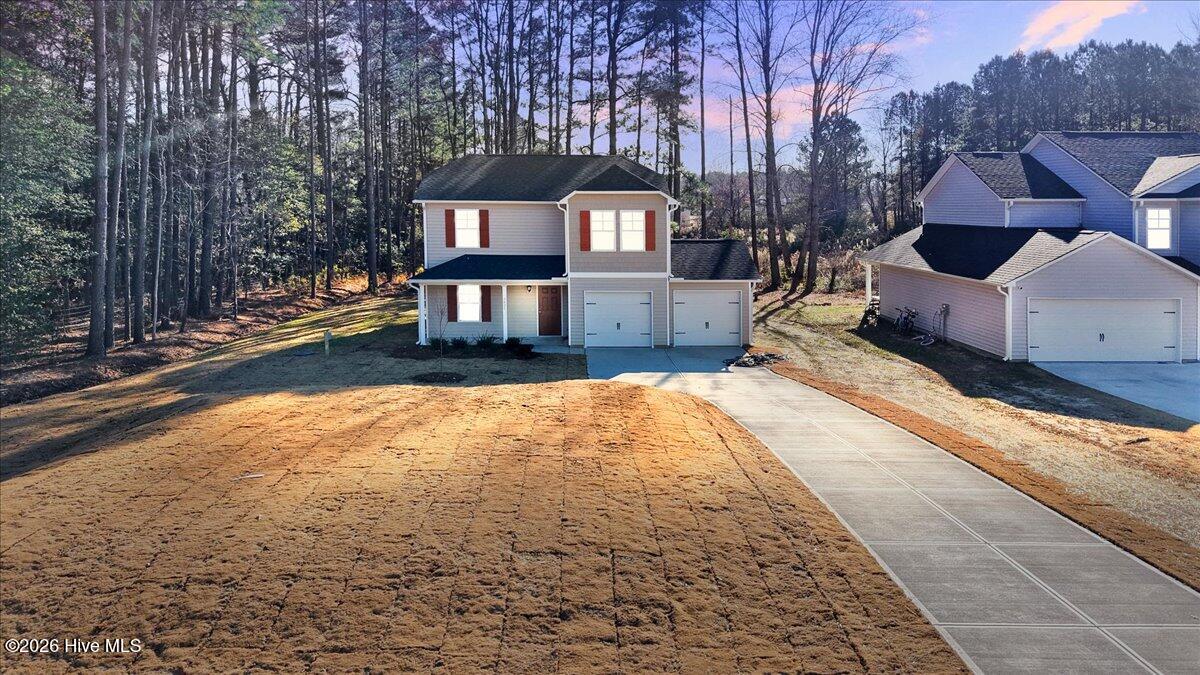 Front exterior of new construction home with warm exterior lighting in Lancaster Place, Castalia NC.