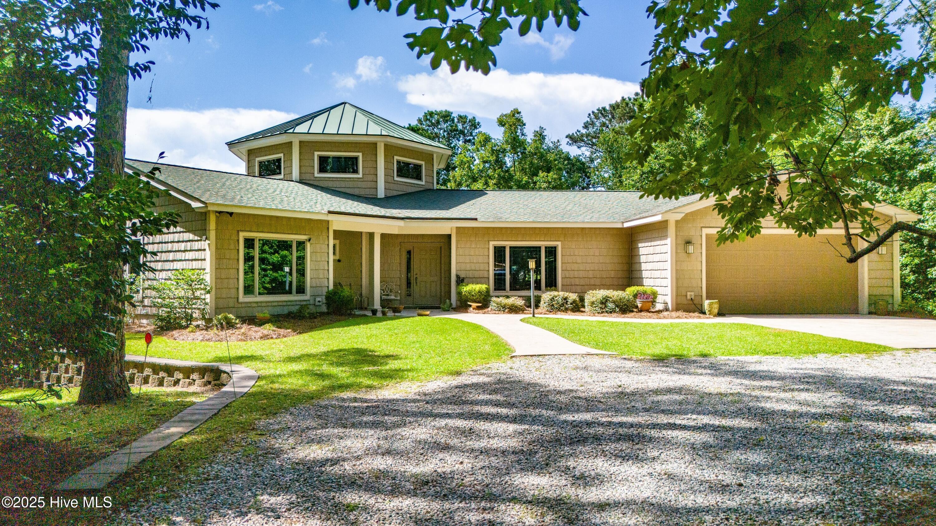 130 Willowbrook Drive Arapahoe, North Carolina Welcome to 130 Willowbrook Drive — a custom-built lakefront retreat where timeless craftsmanship meets modern comfort in the heart of Arapahoe. Situated out of the flood zone and just minutes from the Minnesott Ferry, golf course, and marina, this exquisite home offers the perfect blend of tranquility and convenience. From the moment you arrive, you'll be captivated by the serene lake views and thoughtful details throughout. A striking cupola with rich wood finishes crowns the main living space, creating warm ambiance and charming nooks ideal for reading or quiet conversation. Expansive Anderson doors open to a wrap-around deck and screened porch, perfect for enjoying peaceful evenings overlooking the water.
Inside, the 3-bedroom, 2.5-bath floor plan features a welcoming formal dining room, a granite-topped kitchen with island, and spacious living areas anchored by a cozy gas log fireplace. Beautiful tile floors, walk-in showers, and a dedicated laundry room add everyday comfort and practicality.
This home was designed for effortless living and year-round enjoyment, with a geothermal heating and cooling system, generator, irrigation system, Kinetico water softener, and ample storage including a charming garden shed.
Whether you're savoring a morning coffee on the screened porch, entertaining friends in the open-concept kitchen, or playing a round of golf nearby, this lakefront gem invites you to embrace the quiet beauty of coastal North Carolina — with the peace of mind of being outside the flood zone.
Don't miss this opportunity to own a rare and beautifully crafted home in a coveted location — just a short drive to Oriental and the best of Pamlico County's waterfront lifestyle.