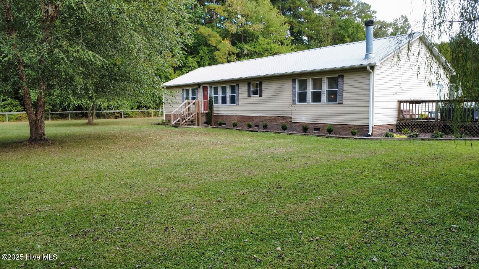 Wow! Take a look at this secluded property located in the rural setting of Jamesville. It starts with over 6.5 acres of mostly fenced-in land that can be used for horses or any other critters you may want to make part of your family. The mature trees give you plenty of shade on the warmest of days, and a gentle wind blowing through the limbs creates just the most calming sound only country living can provide. When you step inside the 1850 sq ft home, you are drawn to the centerpiece of the home: the updated kitchen. It features new cabinets with beautiful granite countertops and a long island to prepare or serve meals. The open concept fosters family inclusiveness, featuring a sunken great room on one side of the kitchen and the dining room on the opposite side. There is plenty of room for a sectional sofa arrangement with a working fireplace, ready to make the space cozy and take the chill away on those cool evenings. The dining room features a handmade table that will surely be the place where memories are made, as your family gathers around to enjoy great meals from the kitchen or play games with the kids. The Main Bedroom is spacious, featuring a barn door that leads to a newly updated bathroom with a gorgeous walk-in shower. There are two other bedrooms and a bathroom that are perfect for the children's living space, or can be used for any purpose you may need. There is also a bonus space that has a closet as well! Outside, you will find a wrap-around deck that can be used for cookouts or simply sitting and enjoying the land's offerings. The entry has a gate that leads you down the path to the home or to the large storage barns. Two separate fenced-in pastures would be ideal for livestock. There is even a Chicken coop area! Additionally, this property features a run-in shelter for horses. If you are looking for country living, you have found it in Jamesville! Call today to set up your showing!