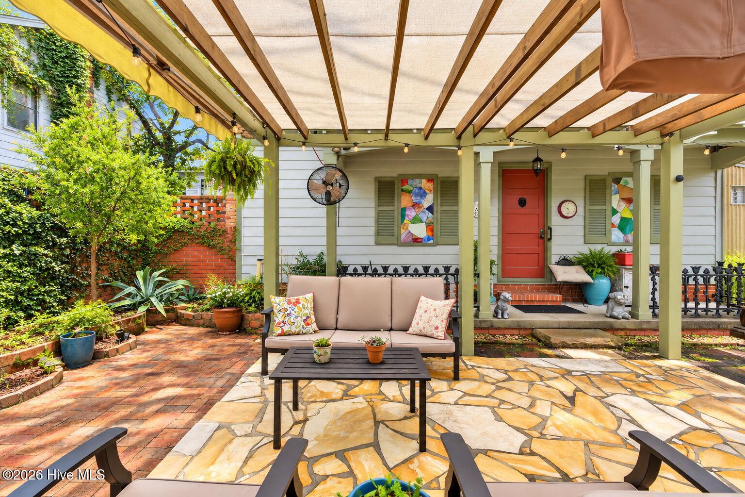 View of detached garage and shaded trellis social area
