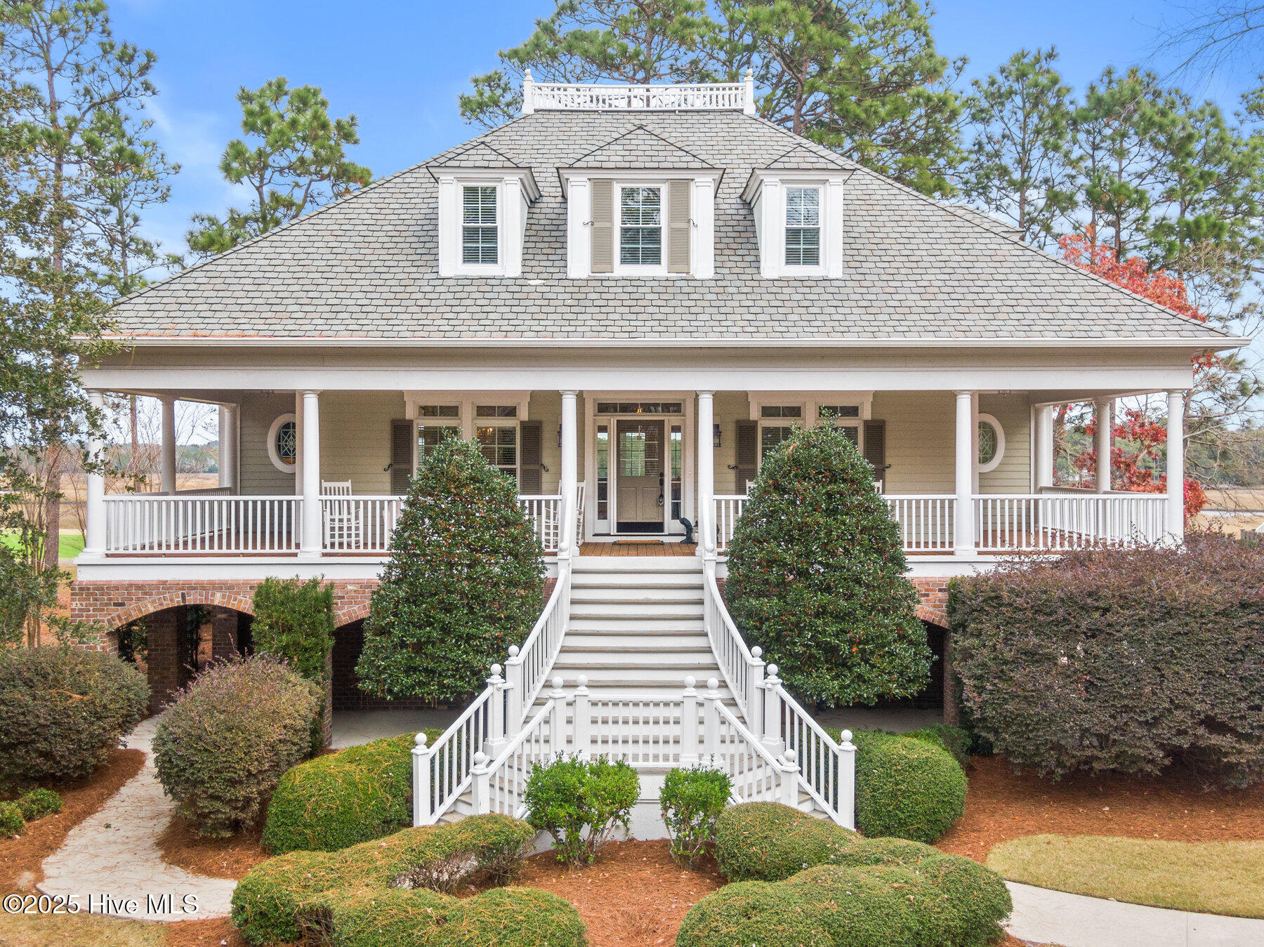 Where the Shallotte River bends and the 17th hole sweeps along the bluff, this furnished riverfront residence offers a quiet coastal beauty that's hard to describe but unforgettable. Morning light rises across the river and pours into the porches and windows-warming coffee cups and setting the tone for peaceful, elevated living in Rivers Edge. Each space invites slowing down: read in the sunroom with 180° views of the river, fairway, and trees; gather in the dining room as the last light fades; prepare meals in a chef's kitchen designed for connection and comfort. Home is being sold furnished with the exception of staging items. With over 4,526 sq ft, the home lives both expansive and intimate, ideal for hosting family, entertaining guests, or savoring quiet mornings. The primary suite offers a private retreat with a softly lit coffered ceiling and steam shower. Multi-level living provides privacy, abundant storage keeps life uncluttered, and a wrap-around porch plus river-facing balconies make the outdoors part of everyday life. From the second-floor balcony, you feel as though you're perched in a treehouse above the greens and tides, with sweeping fairway and river views, birds at eye level, and deer wandering below. It's a private sanctuary where nature is close enough to touch, and peace seems to find you without effort.Thoughtful features include full-thickness oak floors, Kolbe windows with removable hurricane shutters, a powered steel shutter in the primary suite, elevator, piped gutters with guards, aluminum fenced yard, and riverfront backdrop along the 17th hole.Rivers Edge offers a lifestyle to match-manned gated entry, indoor/outdoor pools, fitness center, tennis and pickelball, Arnold Palmer-designed award winning golf course, walking trails, and an exclusive oceanfront clubhouse at Holden Beach.If you're looking for a home that does more than meet needs- but feeds the soul through light, water, and quiet moments - this is it.