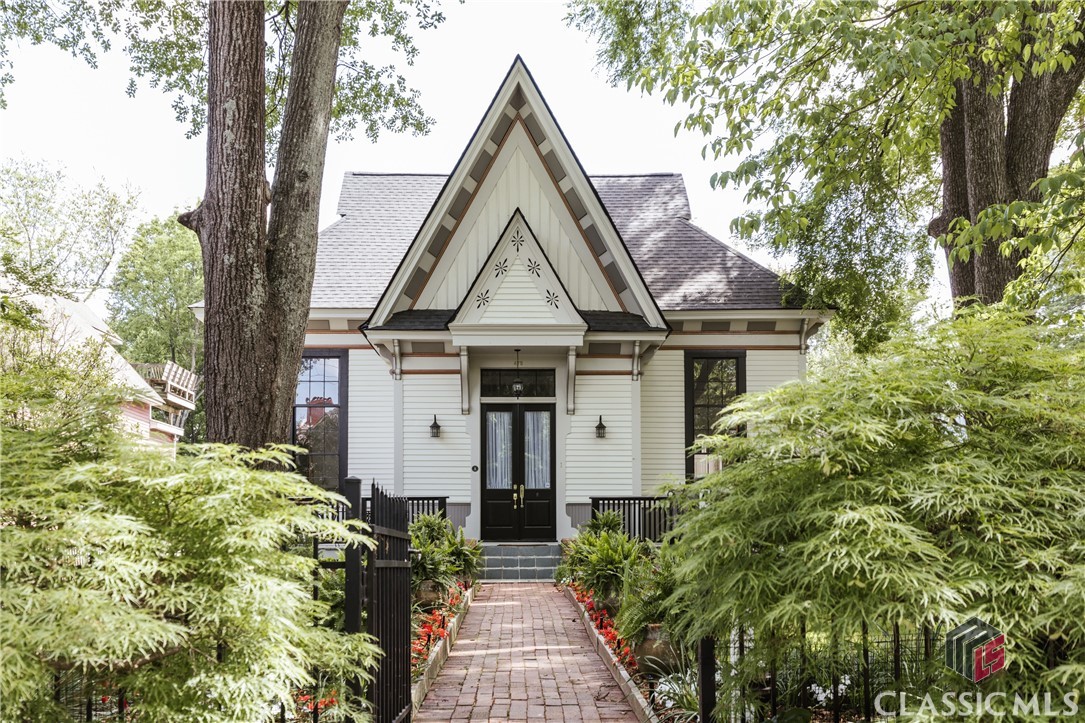 Incredible opportunity to own a beautifully restored Gothic Revival home in Cobbham Historic District. 475 Meigs Street is an Athens icon with one-of-a-kind architectural features recognizable by anyone who has spent even a short amount of time in the Classic City. The original property comprising half of a city block served as one of Athens' first schools, The Meigs Street School, until 1918. Many of the original structures still stand today and have been converted into residences. The home, constructed c. 1873, is sited a notable distance from the street which allows a delightful fenced front yard - a gardener’s paradise with many mature trees, perennials, and a sizable water feature with Koi fish. There are many areas of the yard to entertain friends and family, and you can wave to passersby who are walking to Downtown Athens or the multiple restaurants in between. Ascending the front steps, you reach the deck that flanks the French Doors. Upon entry, a breathtaking view of the Greatroom enveloped in natural lighting courtesy of four restored, triple-hung windows. Heart of pine flooring runs throughout the main level of the home with exception to the oak inlay at the center of the Greatroom and Brazilian Cherry in the Primary Suite. Wide baseboards, gorgeous moldings, and stately columns are a testament to the craftsmanship of yesteryear. The floorpan lends itself to entertaining and dinner parties with a dining area that seats twelve. The kitchen features ample, freshly painted custom cabinetry, stainless steel appliances including a double wall oven, granite countertops, and another gorgeous, triple-hung window. The Primary Suite features Brazilian Cherry floors and a spacious ensuite bathroom with wide vanity, Jacuzzi tub, and separate shower. Through the ensuite bathroom is the walk-in closet complete with custom closet system and eye-level windows spanning the length of the outside wall. Two secondary bedrooms, one featuring a custom loft, share a hall bathroom. The laundry room has a wall of storage shelves perfect for your sundries and houseplants. 475 Meigs Street consists of three unique living spaces. The main level consists of three bedrooms, two bathrooms, and has soaring ceilings. Upstairs, you will find the Mother-In-Law Suite featuring ample living space, two bedrooms, a full kitchen, full bathroom, and laundry. Multiple skylights and clerestory windows bring in the sunlight while also allowing extra privacy. Ample built-in storage and closets in this suite to boot. An adorable cottage located in the side yard has a studio layout to include a full kitchen and bathroom plus a lofted bed. The current owners have experienced great success with Airbnb and long-term tenants occupying the guest suites should a new owner wish to live on the main level and generate passive income. Need more storage? The 500+ square foot unfinished basement is perfect for hiding your excess possessions, creating a man-cave, or workshop. This is the epitome of In-Town Athens living - walk, roll, or scoot to all the excellent dining and shopping options on the Prince Avenue Corridor, Bottleworks, and Downtown Athens. The University of Georgia’s historic North Campus is just a stone’s throw away. Schedule your private tour today!