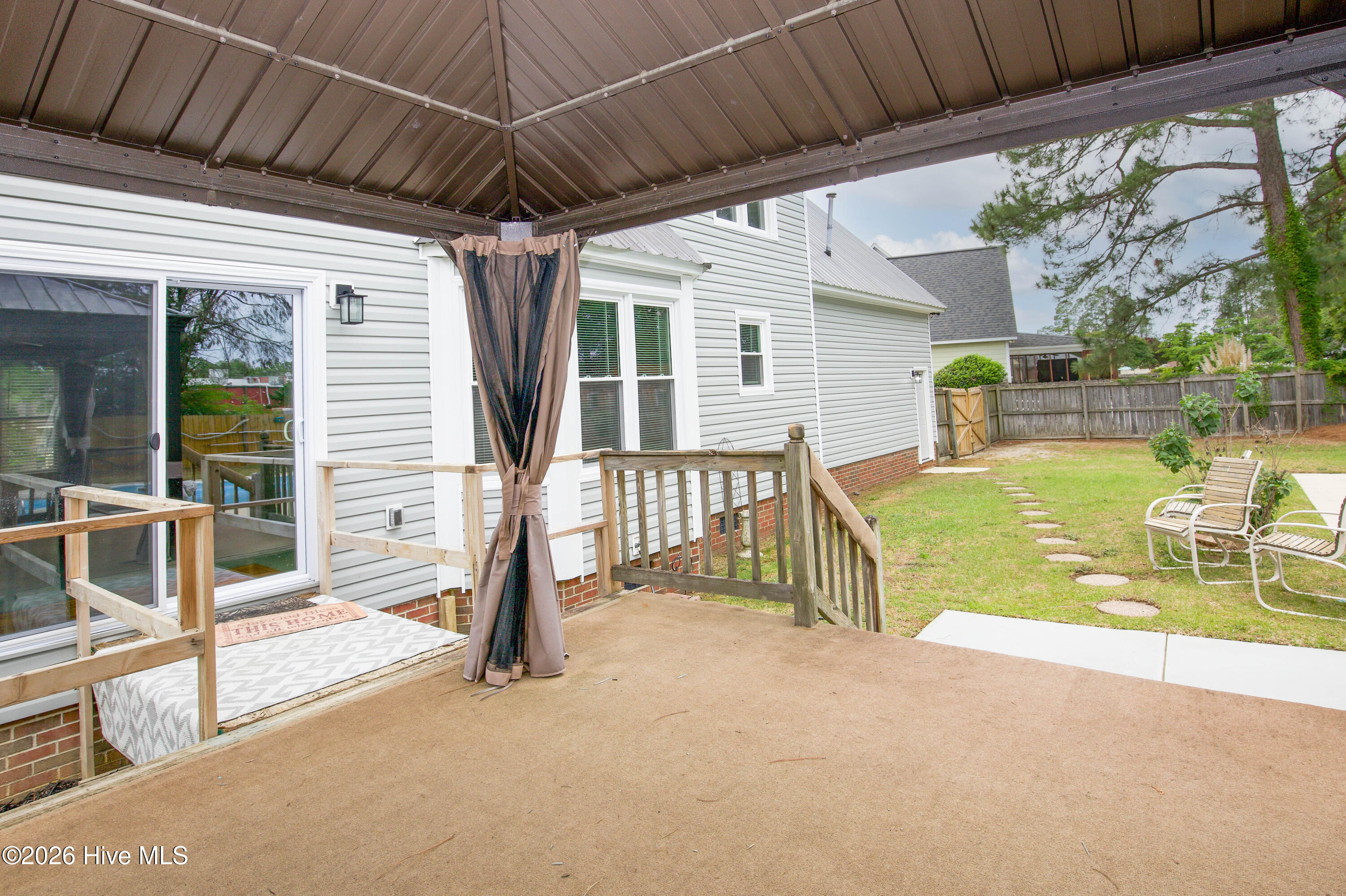 Covered gazebo and elevated outdoor living space designed for relaxing, entertaining, and enjoying the backyard retreat year-round. This flexible outdoor area overlooks the fenced yard and pool while providing shaded seating space ideal for gatherings, cookouts, or peaceful evenings outdoors. Homes with dedicated outdoor entertaining areas continue to attract strong interest from Fayetteville and Fort Bragg buyers seeking lifestyle-focused properties with no HOA restrictions.