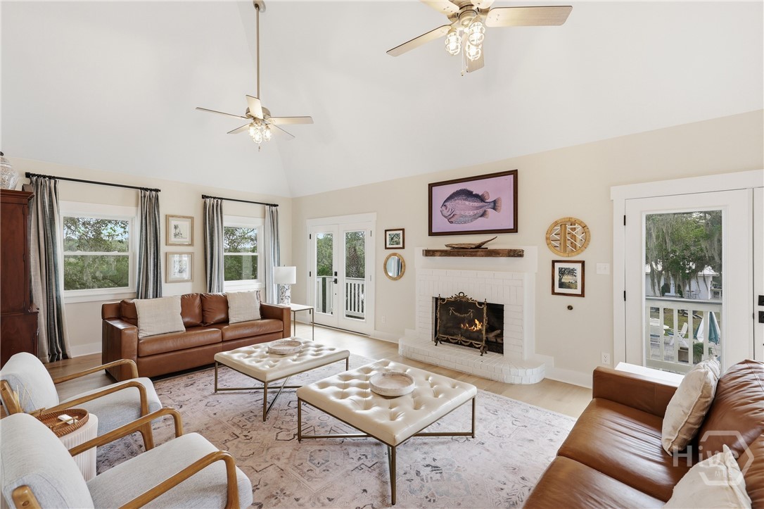 Vaulted ceilings in family room with gas fireplace and abundance of light from windows and French doors with river views on all three sides of the home