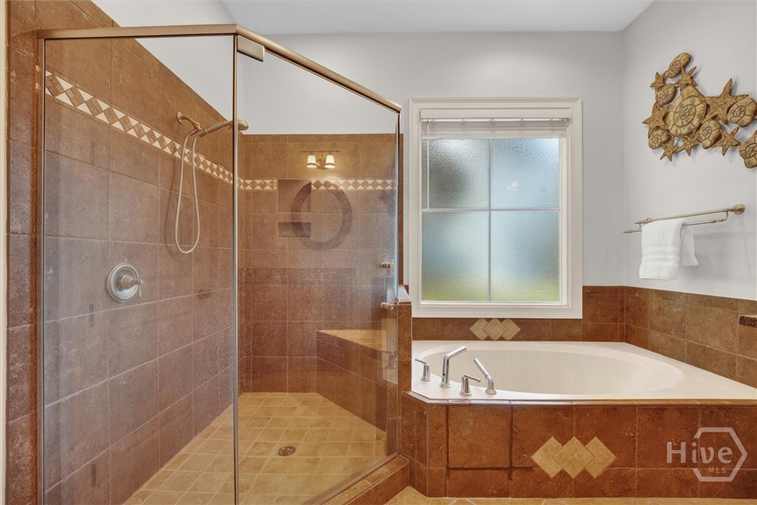 Primary en-suite has a large garden tub and a roomy corner walk-in shower with seat