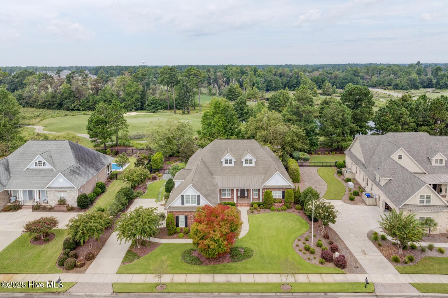 Welcome to 3012 Cobden Court, perfectly situated on a quiet cul-de-sac in the highly sought-after Cape Fear National section of Brunswick Forest. This beautifully landscaped .40-acre home sits along the 9th hole with lovely views of the green, offering a peaceful golf course setting. Designed for relaxed indoor-outdoor living, it features an inviting front porch, spacious patio with a remote-powered Sunbrella awning, fenced backyard, and a sunroom overlooking the course.  Inside, hardwood floors flow through the main living and dining areas and the primary suite, which includes two walk-in closets. With four bedrooms plus an office, the home provides space and flexibility for guests or work-from-home needs. Enjoy the exceptional amenities of Brunswick Forest—three outdoor pools, an indoor pool, fitness centers, tennis and pickleball courts, walking and biking trails, parks, and a dog park—along with the nearby commercial village offering convenient shopping, dining, and medical services. Cape Fear National's award-winning golf course and optional memberships provide access to the clubhouse, restaurant, and outdoor terrace, all just minutes from downtown Wilmington and the area's beautiful beaches.