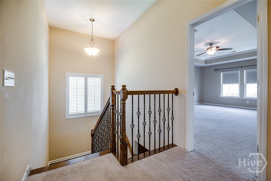 Landing at the top of the stairs - Large window at the landing has custom plantation blinds- looking into Primary