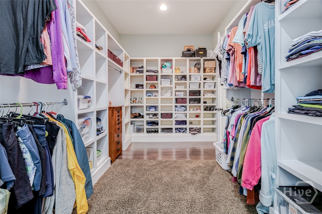 Large primary suite closet with wood built ins