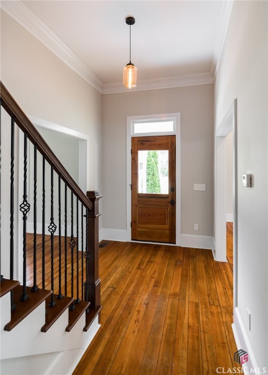 This 1920s farmhouse in Social Circle combines historic charm with modern upgrades. Original hardwood floors, wooden corbels under the eaves of the front porch, and a beautiful, intricately carved wooden front door with antique glass seamlessly blend with the modern renovations.  The open floor plan of the main level showcases the custom-designed kitchen that flows into a spacious dining area and a great room, with soaring ceilings and beautiful windows all around.  The kitchen features granite countertops, tile backsplash, copper farmhouse sink, walk-in pantry and stainless steel appliances. The primary suite boasts a large walk-in closet, clawfoot tub, double vanities, and a walk-in shower with a rain showerhead.  Also on the main floor is a secondary bedroom with an ensuite bathroom and walk-in closet.  There is a room at the front of the home perfect for a home office, library, or playroom.  The original grand stairwell will take you upstairs to a landing area, ideal for a window seat or a small desk, and two bedrooms with a jack-and-jill bathroom. The exterior features a wraparound porch, stamped concrete driveway, and a back deck overlooking a huge, flat backyard.  Upgrades include molding, pendant fixtures, recessed lighting, granite in the bathrooms, French drain system and an encapsulated crawlspace.  Located within the historic district of Social Circle, sidewalks will take you to a coffee shop, restaurants, and retail around the town’s famous well.  Or you can hop on your golf cart and head right up the street. Easy access to I-20 for a commute. Immaculately preserved historical charm, contemporary finishes with modern renovations, and a desirable downtown location, you don’t miss out on claiming this piece of history as your own. There is nothing else like this on the market!