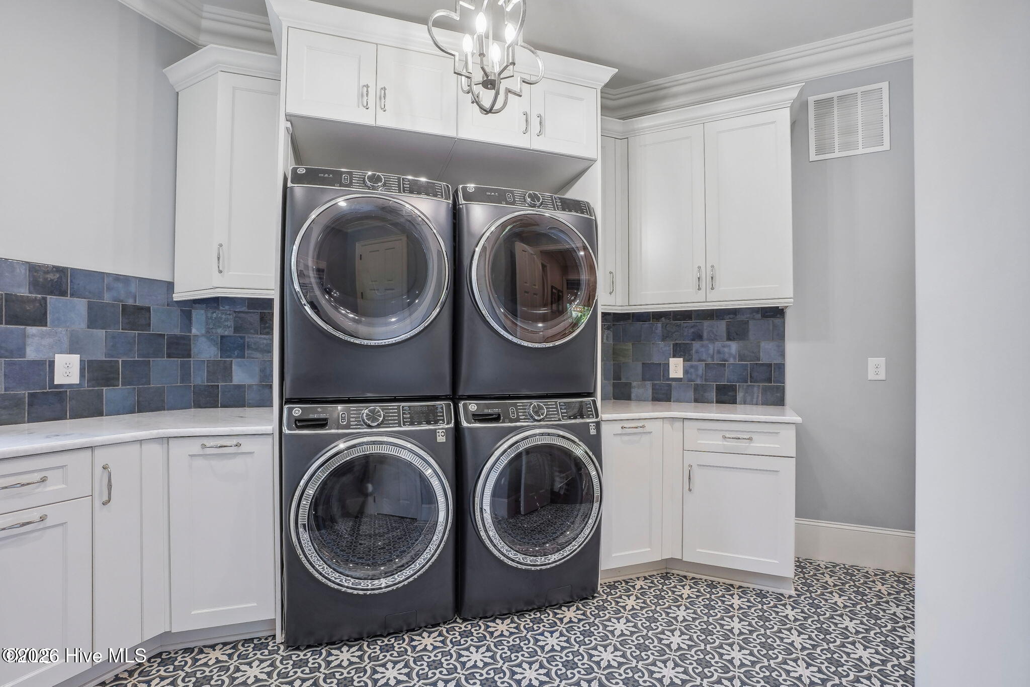 First floor laundry room off of kitchen with twin GE power steam washers and dryers with additional