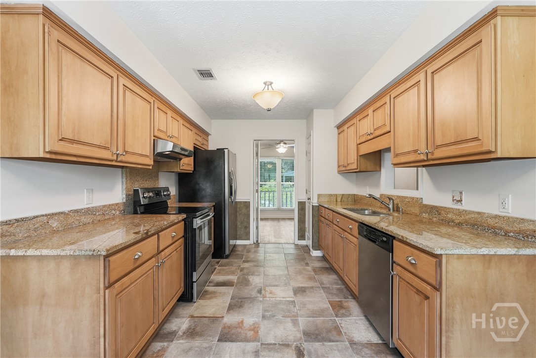 Kitchen with granite counters and stainless appliances, tile floor