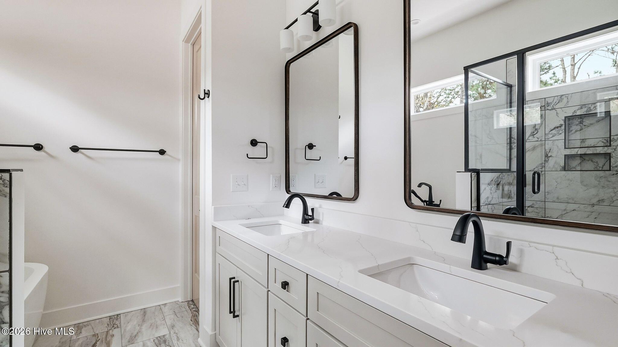 Primary bathroom with double vanity and quartz counters