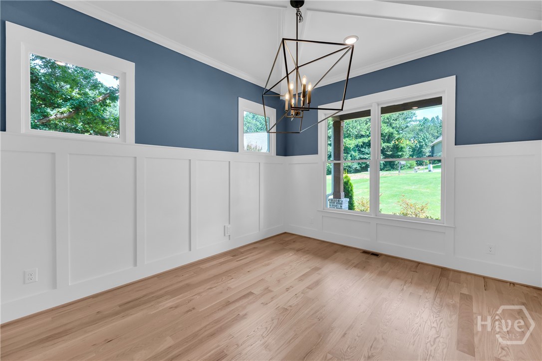 Light wood-finish flooring complements the white board and batten wall treatment in the Dining Room