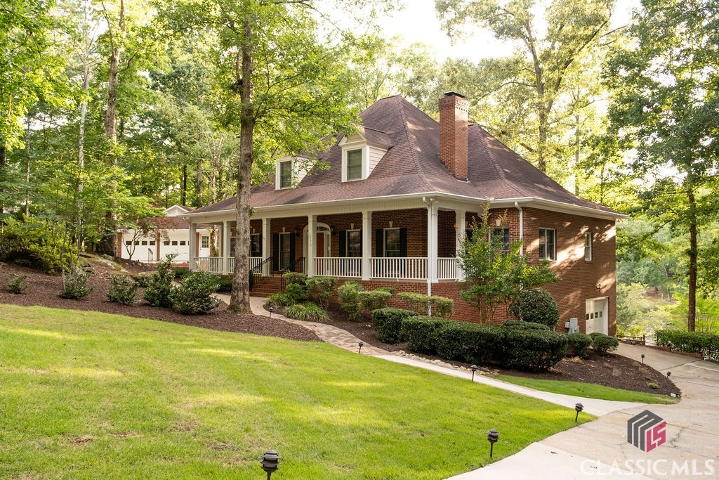 Lakeside Living Retreat—-A rare, sought-after find in Athens, the coveted Shoal Creek community boasts limited lake living opportunities and this custom beauty is not only one of the few that boasts a picturesque lakeside setting, but also offers an amazing level rear yard to help you enjoy it all!! Upon approach the ethereal backdrop is stunning—set with custom landscaping, brick walkways, dual driveways, detached 2-car garage, and wrap-around front porch all drawing you in. Not your everyday plan, this expansive footprint was custom designed to not only provide ample space for room to expand, but was also crafted to enjoy sparkling lake views from many angles. Welcomed by the formal layout, the foyer is flanked by a spacious formal dining room that could easily seat 8+ and a grand living room with central, marble-accented fireplace commanding the space. Tucked away off the living room is the ideal home office or study, perfectly sunlit. By now you’ve noticed several desirable features that appoint this lovely home, such as; 10ft. ceilings, hardwood and ceramic tile floors, new upgraded plush carpet, extensive trim and moldings package, decorative light fixtures-many with dimmers, double paned windows, floored attic storage options, and more. Serving lake house vibes, the entertainer’s kitchen overlooks the sunroom styled breakfast room and keeping room engulfed with views of the lake. Well-equipped, the spacious kitchen features 360’ of custom cabinets, sprawling granite counters that extend to the breakfast bar, tile backsplash, double-basin, under-mount sink with instant hot water dispenser, large pantry with shelving, and a complete appliance package including wall oven. The cozy keeping room boasts a masonry fireplace flanked by custom builtins, and is the heart of the home where many memories will be shared. Down the hallway you will find many conveniences like the laundry room complete with utility sink, powder room perfect for guests, access to the terrace level and tucked away at the end, the private owner’s suite. A true retreat, this oversized primary bedroom offers ample space for large furniture, multiple spacious closets, ensuite full bath and of course lake views. Start your morning off right with the picture windows reflecting the lake in the primary lavatory, or enjoy a bubble bath for added relaxation. Ascend the stairs to find 3 additional bedroom options, plus 2 full baths. The upper level also houses an additional bonus space or home office that provides access to stairs leading to the 3rd floor attic storage. If you enjoy entertaining, in need of room to expand or looking for inlaw suite potential the finished terrace level is ready to serve. Boasting an oversized rec. room, wet bar with cabinets perfect for a kitchenette, full bath, lower level garage and exterior access, this daylight basement provides upgraded amenities that allow the space to be utilized in many ways. The desirable features continue to the exterior where you can enjoy year-round living with the screened porch or enjoy dining al-fresco lakeside on the oversized rear patio. Follow one of the stone or concrete paths to the fenced rear yard, lower level patio, and banks of the lake to relish in a little afternoon fishing. The exquisite scene this 1.01 acre lot exudes must be seen in person to truly appreciate its authenticity and beauty. Welcome home to Millstone Circle.