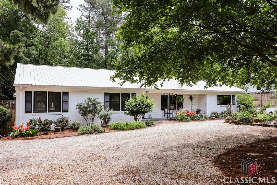 Experience the finest in modern comfort with this beautifully renovated four-bedroom, three-bath ranch located in the highly desirable Five Points neighborhood. Perfectly move-in ready, this single-story residence combines contemporary updates with timeless charm, offering a spacious and functional living environment.Situated on a generous, level lot just under half an acre, the property provides ample potential for expansion and outdoor enjoyment. The expansive, open floor plan encompasses approximately 2,400 square feet of thoughtfully upgraded living space. Distinctive features include ship lap ceilings in the main living areas and kitchen, along with an original wood-burning fireplace that adds character and warmth.The generously sized living room seamlessly connects to a bright sunroom and a sizable dining area, ideal for entertaining. The updated kitchen showcases a large picture window overlooking the meticulously maintained backyard, a gas range with an exposed vent hood, and an original live-edge wood breakfast bar. Additional amenities include a vintage penny tile backsplash and two spacious pantry/closet storage spaces.A converted screen porch now serves as a versatile sunroom—perfect for a home office or reading nook—bathed in natural light. The owner’s suite, located at the rear corner of the home for privacy, features three closets for ample storage and a newly renovated bathroom with a large tile shower, soaking tub, and separate lavatory closet.Two secondary bedrooms share a full hall bath, while the fourth bedroom, situated on the opposite side of the residence, includes an en suite bath with a large tile shower, French doors leading to the back patio, and can function as an in-law or guest suite. This flexible layout is ideal for accommodating guests or family members.Recent upgrades include new energy-efficient windows with a lifetime warranty, a durable metal roof, and impressive landscaping with drought-tolerant perennials, a large custom-covered patio, and a modern irrigation system in both front and rear yards for minimal maintenance. The owner has also cultivated beautiful garden beds, enhancing the home's curb appeal.Conveniently located close to Five Points, the University of Georgia, shopping centers, and local amenities, this exceptional property offers the perfect blend of tranquility, style, and accessibility. Schedule your showing today and make this outstanding residence your new home.