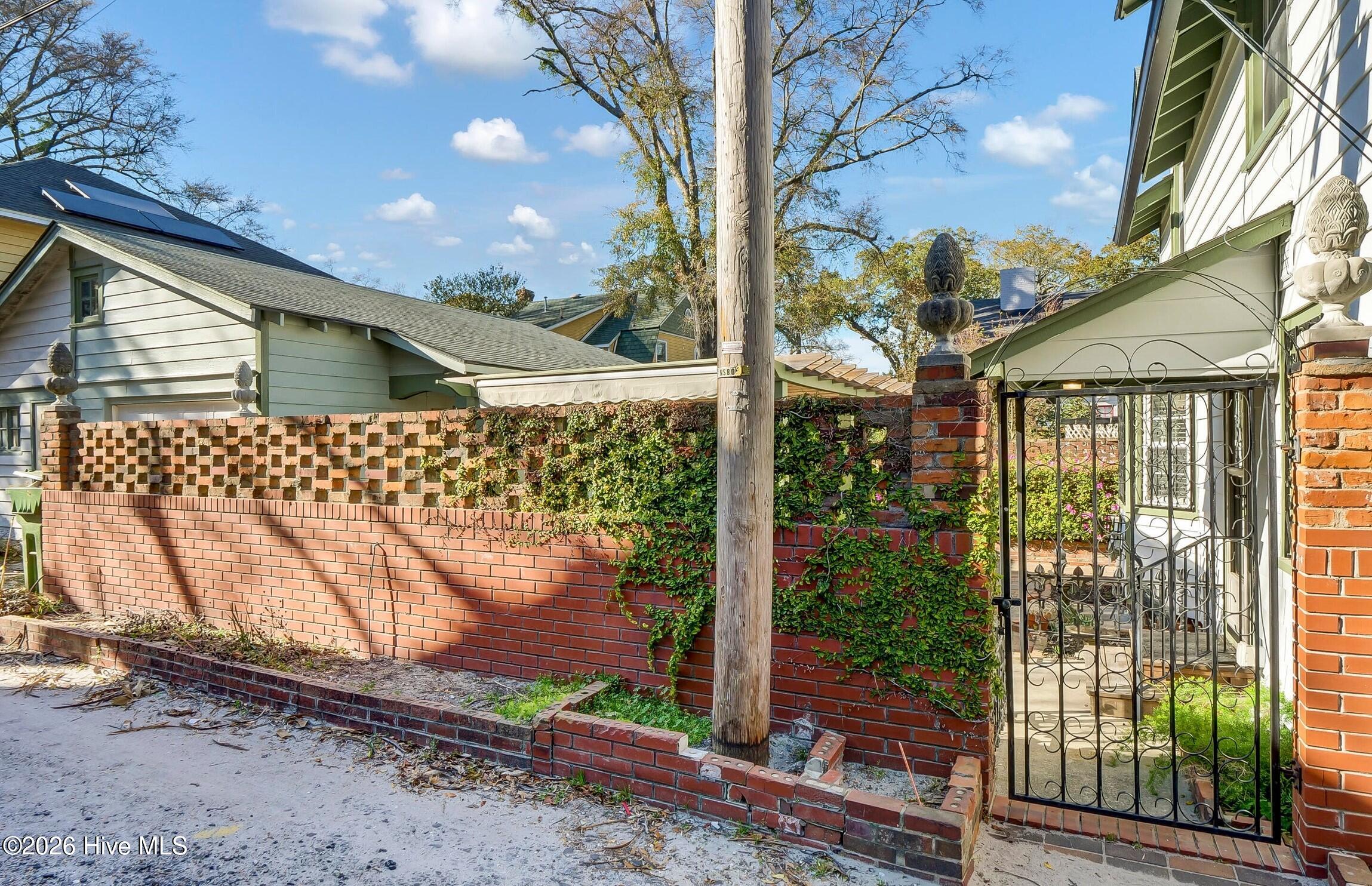 Side alley access to detached garage. Backyard contained within Historic brick privacy walls