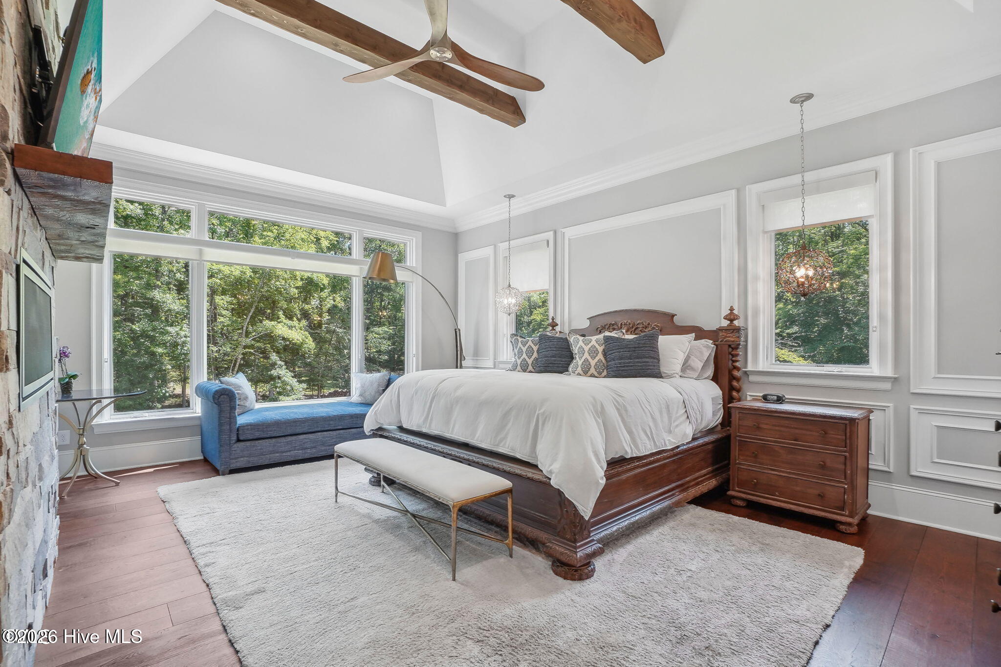Master bedroom with huge picture windows vaulted ceiling with oversized rustic beams and contemporar