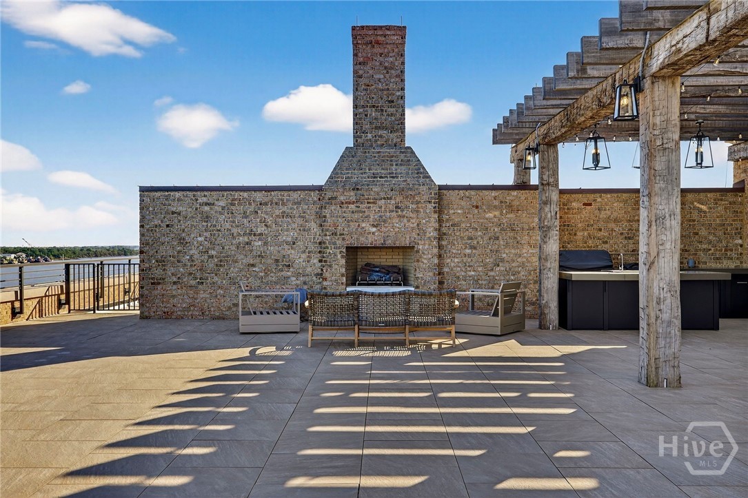 This waterfront rooftop terrace, exclusive only to the Penthouse, combines a central fireplace with a pergola-covered kitchen and bar area. The layout supports both intimate seating and culinary entertaining, framed by scenic views and architectural charm. A refined outdoor extension for year-round enjoyment.