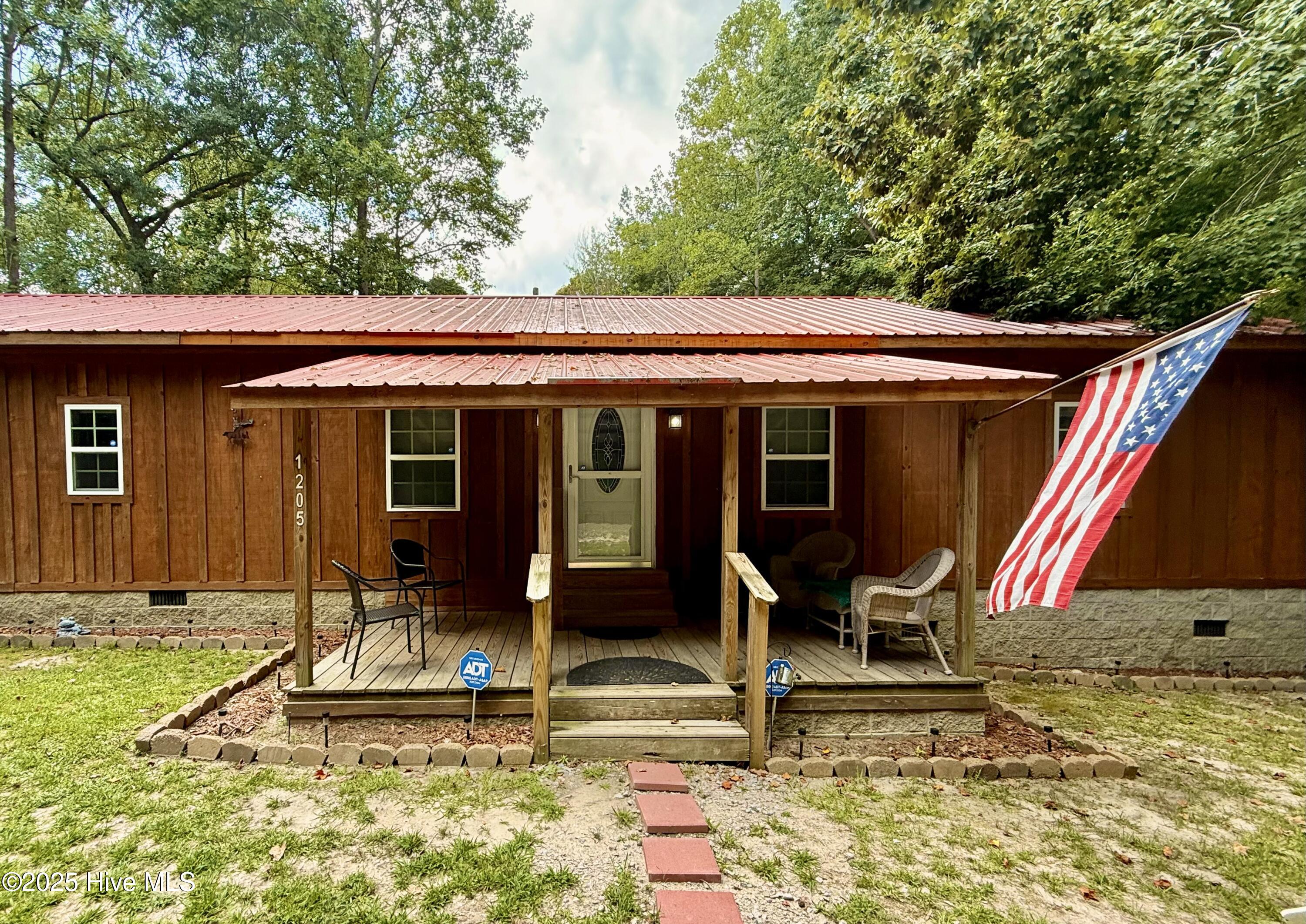 Discover the perfect blend of rustic charm and modern comfort in this unique single-wide, beautifully converted into a cozy cabin on a peaceful half-acre lot. Step inside to find an open-concept living space that combines the family room, kitchen, and dining area, with two bedrooms, a full bath, and a spacious laundry room. Originally built in 1974. Custom woodwork done in 2013-2015 adds warmth throughout, and a sunroom/bonus room offers serene woodland views and a glimpse of a backyard pond (No permits on file for the sunroom or septic tank) Property is located off private road, no standing maintenance agreements. The vin# for the home is unknown. Willing to consider seller financing otherwise CASH ONLY and seller is not willing to conduct any further repairs, AS IS. Located just 30 minutes from Greenville, 25 from Tarboro, and 14 from Williamston enjoy the best of both worlds, privacy and proximity!