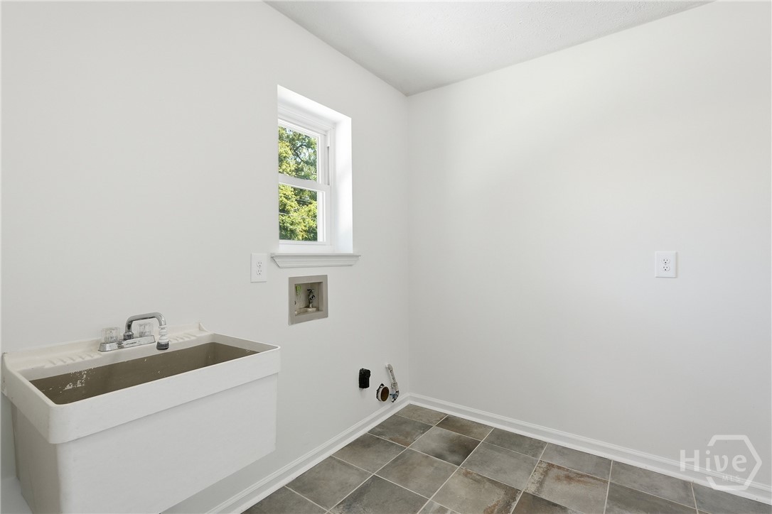 Laundry room off the garage has tile floors and a handy sink. Accepts both gas and electric appliances.