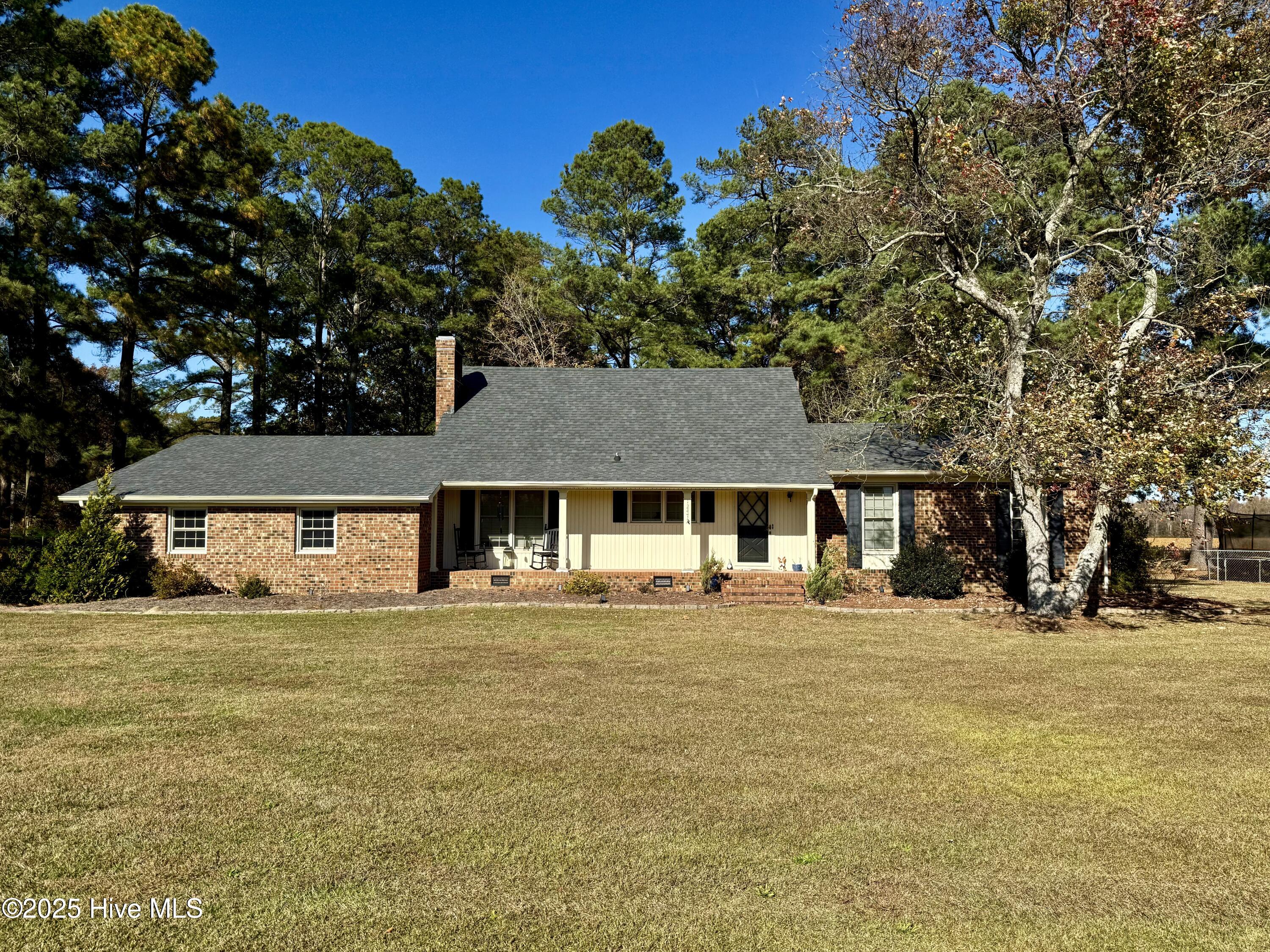 Welcome to paradise! This stunning home is truly an entertainer's dream, offering a perfect blend of charm, comfort, and functionality. As you step into the elegant foyer, you'll be drawn to the spacious kitchen, complete with stainless steel appliances, abundant cabinet space, and an open dining area featuring a cozy wood-burning fireplace—ideal for hosting gatherings or enjoying quiet family meals. The sunken living room, with its gorgeous oak hardwood floors, flows seamlessly into a delightful piano room, creating a warm and inviting atmosphere. A convenient half-bathroom is also located on the main floor for guests.The downstairs layout includes two guest bedrooms that share a hallway bathroom, as well as a primary bedroom with its own private ensuite featuring a step-in shower for ultimate comfort and privacy. Upstairs, you'll find two additional carpeted bedrooms that share a full guest bathroom, along with walk-in attic storage space to meet all your organizational needs. The home also boasts an attached two-car garage for added convenience.Step outside and prepare to be wowed by the outdoor oasis. The above-ground pool and hot tub are beautifully integrated into a grand gated wooden deck, surrounded by privacy fencing to create your own secluded retreat. A small chain-link fenced area adds versatility to the backyard, while the detached brick double-car garage provides extra storage or workspace and complements the home's aesthetic perfectly.Situated on a corner lot less than half a mile from US Hwy 17, this property offers both convenience and flexibility with no zoning restrictions. Whether you're looking for a place to entertain, relax, or simply call home, this property has it all!
