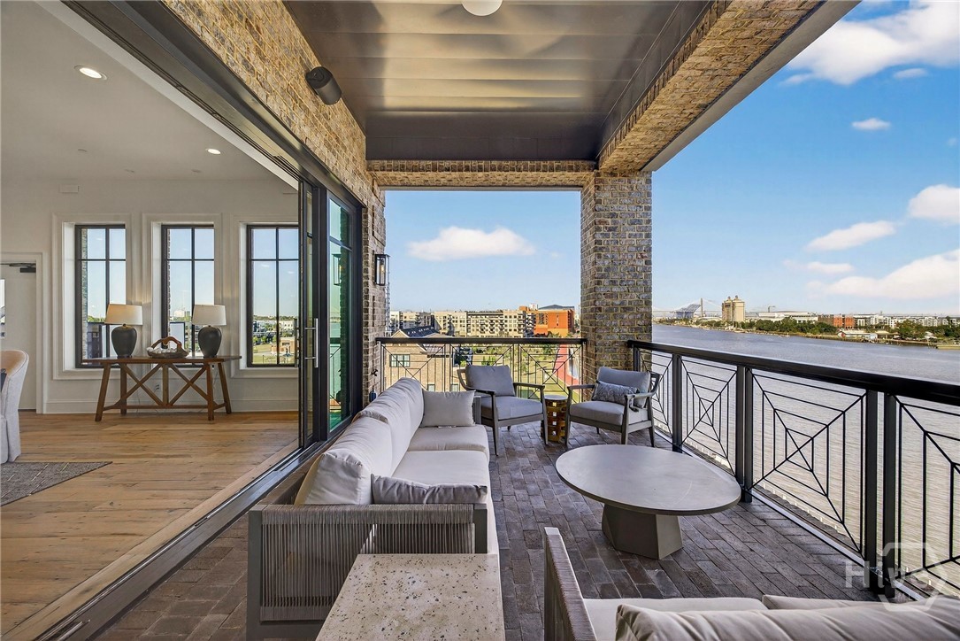 This private balcony off the dining room offers panoramic views of the river and skyline, seamlessly extending the living space outdoors. Brick flooring and geometric railing details frame the elevated setting, while recessed lighting enhances evening ambiance. An ideal perch for urban serenity and entertaining.