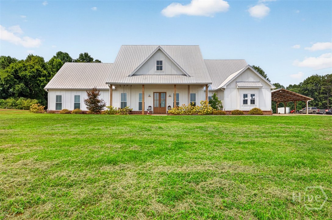 Welcome home to 1475 Storey Lane in Jefferson, GA. This custom farmhouse sits on 33.48 gorgeous, sprawling acres. The stunning home boasts, 5 Bedrooms, 4 ½ Bathrooms, 3-car garage, tons of outdoor living space, a separate 30’x30’ carport, and a 30’x50’ workshop. Come on in through the stained, double doors as you will be welcomed in the foyer. The large dining room is a great place to gather and enjoy meals with a view of the huge front yard. The chef’s Kitchen is a cook’s dream complete with Bertazzoni premium kitchen appliances, quartz countertops, cabinets to the ceiling, floating shelves on either side of the Kitchen window, a pantry with wood shelving, and a large island with plenty of storage. The Family Room features 11ft ceilings, a brick fireplace to ceiling with bookcases, and laminate wood flooring that is on the whole main level of the home. The oversized Primary Bedroom is on the opposite side of the home that has a beautiful accent wall. The barndoor leads into the Primary Ensuite that has a free-standing tub, tile shower, two separate vanities, and two separate custom closets. The large laundry room is filled with cabinets and a sink. There are three other secondary Bedrooms on the main level with accent walls & walk in closets, 2 Full Bathrooms, a Home Office, a Powder Room and Mudroom. Upstairs is a huge bedroom with its own ensuite and walk in closet. The home has speakers in the Family Room, Kitchen, 3-car garage, and on the covered back porch. The covered back porch is the best place to watch football games with an outdoor fireplace, vaulted ceiling with heaters, an abundant space to entertain, and the start of an outdoor kitchen. The large 30’x50’ metal workshop has 4 garage door bays and features a Rotary Lift that can hold 10,000 pounds, which makes a great spot for all of your toys and to hang out! This property is a must see as the front yard is wide open and the back yard is woods, so you get the best of both worlds in your own private oasis. Welcome home to 1475 Storey Lane!