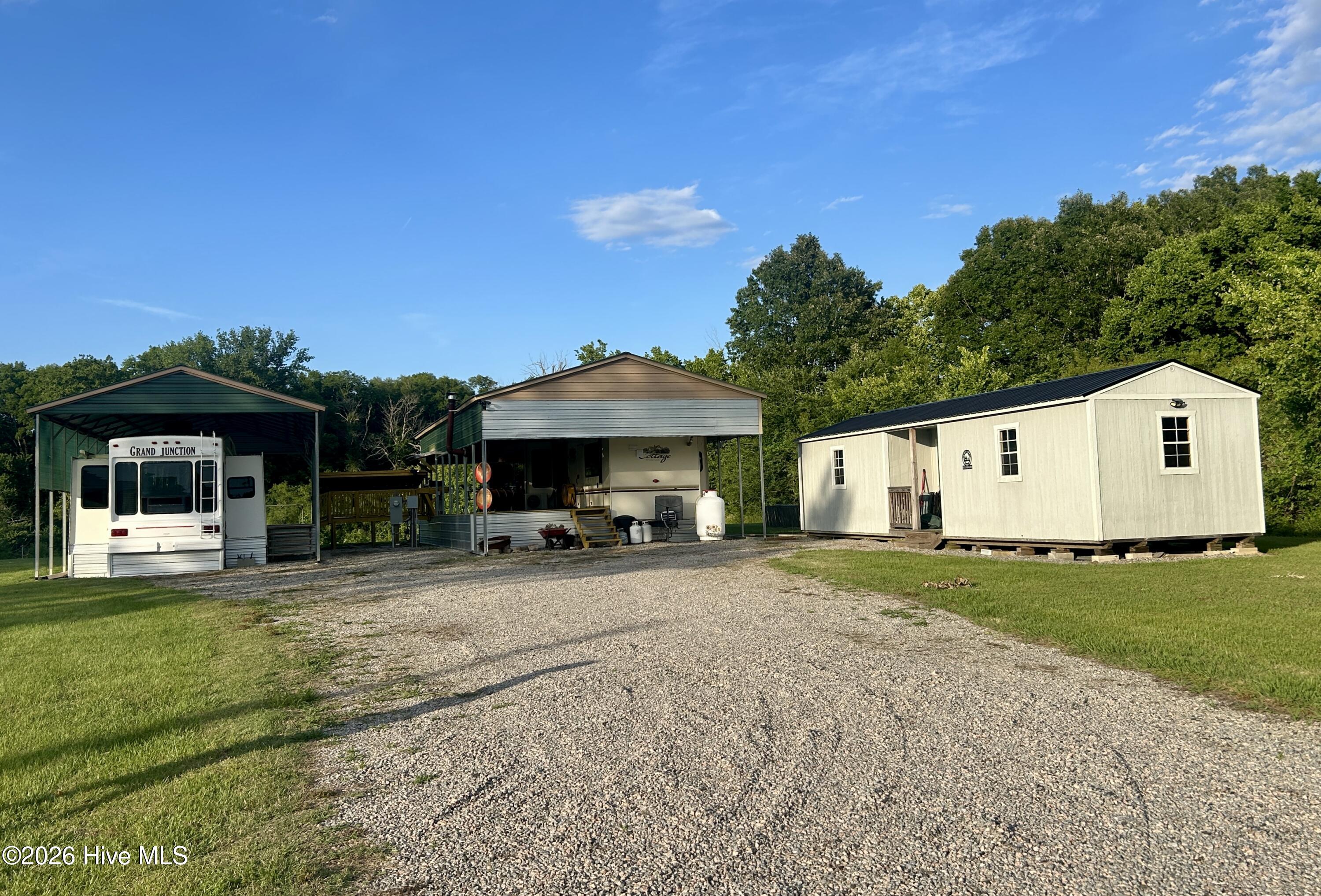 driveway view of campers and storage building