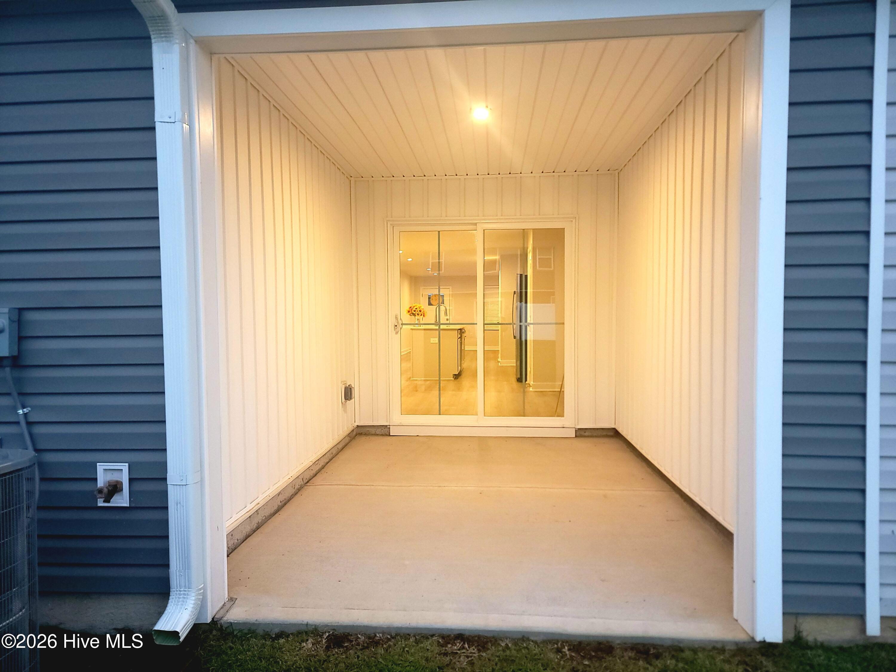 A unique feature! This is the back patio which is enclosed on three sides. Enjoy your privacy. Glass doors lead to kitchen area.