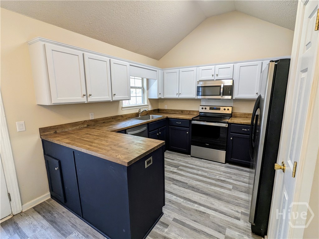 Kitchen.  Butcher block countertops and stainless steel appliances.