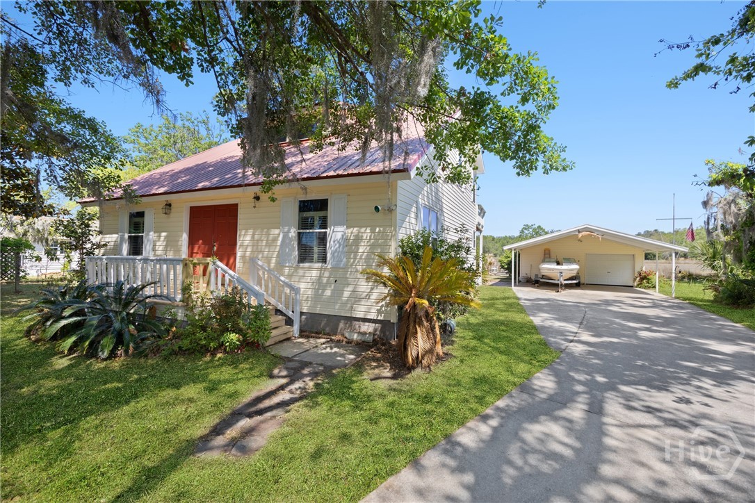 Side approach showing long driveway, detached gara