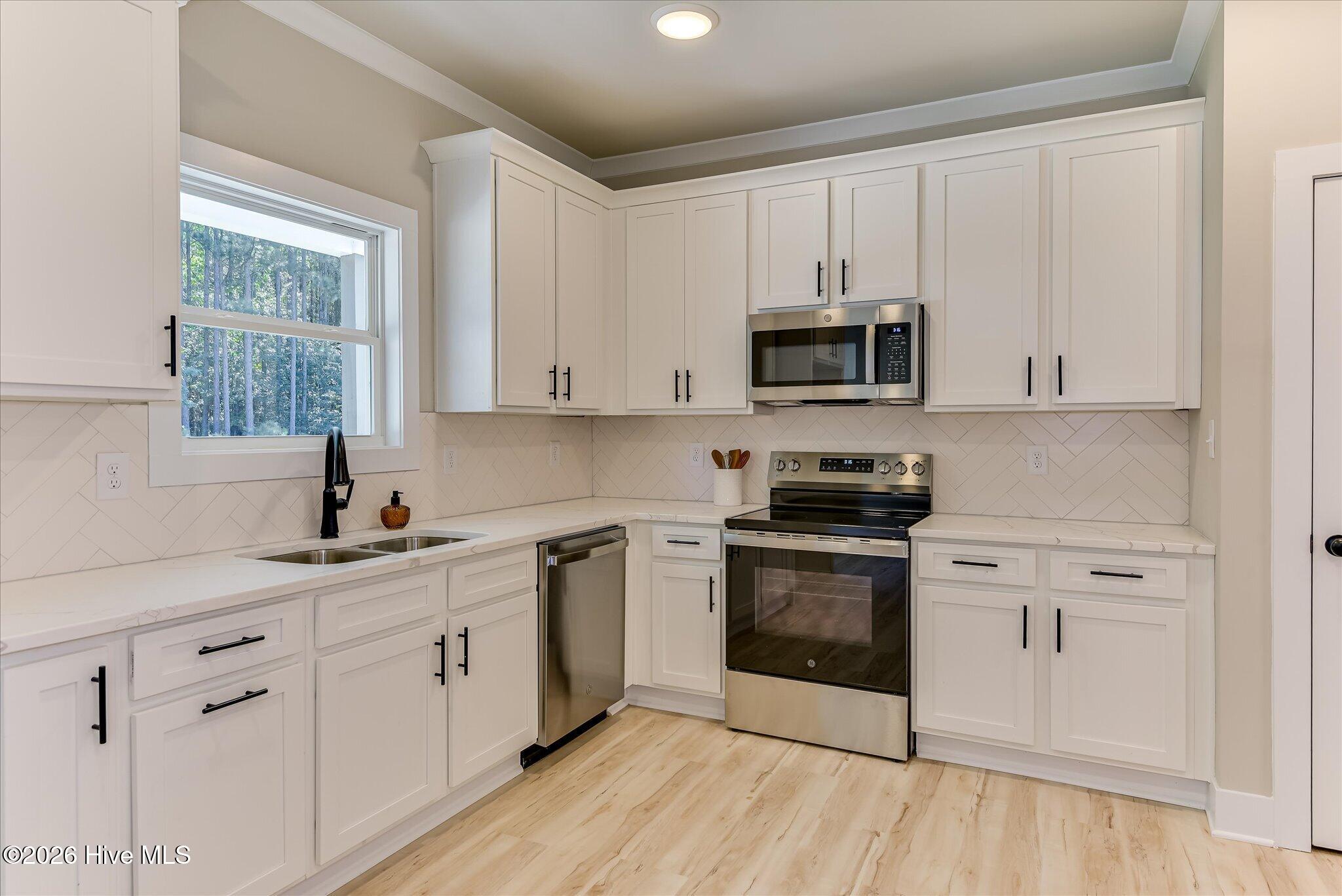 Well-equipped kitchen with quartz countertops, stainless steel appliances, and pantry