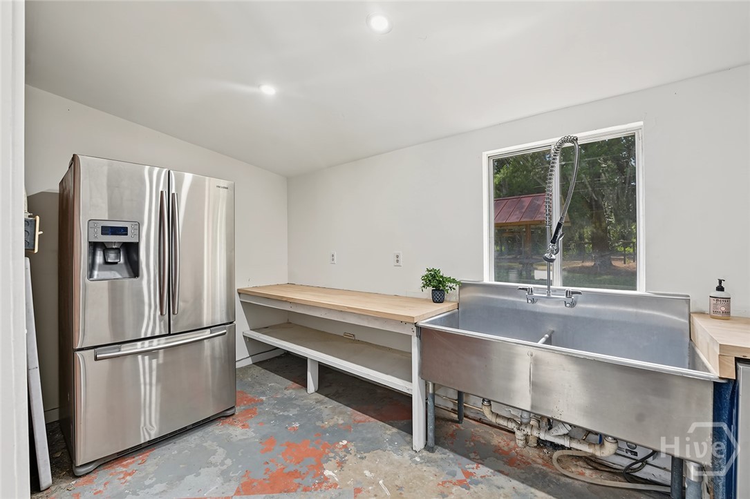 Party barn kitchen with second fridge, industrial sink, and dishwasher