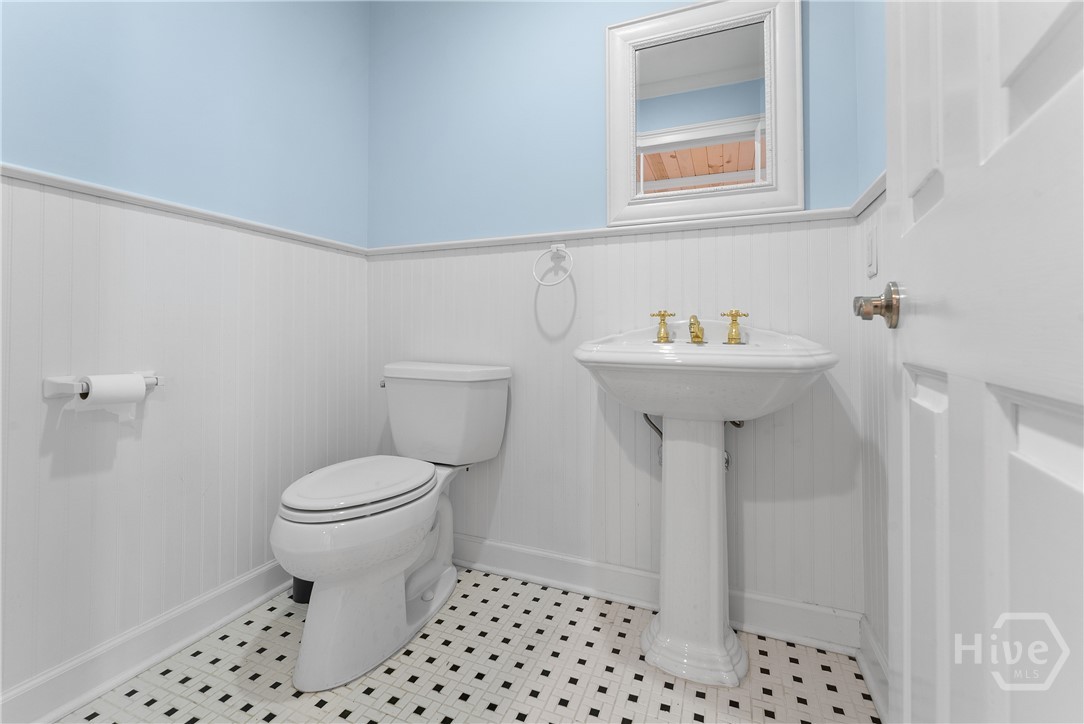 Half bath with classic basket weave tile, bead board walls and pedestal sink