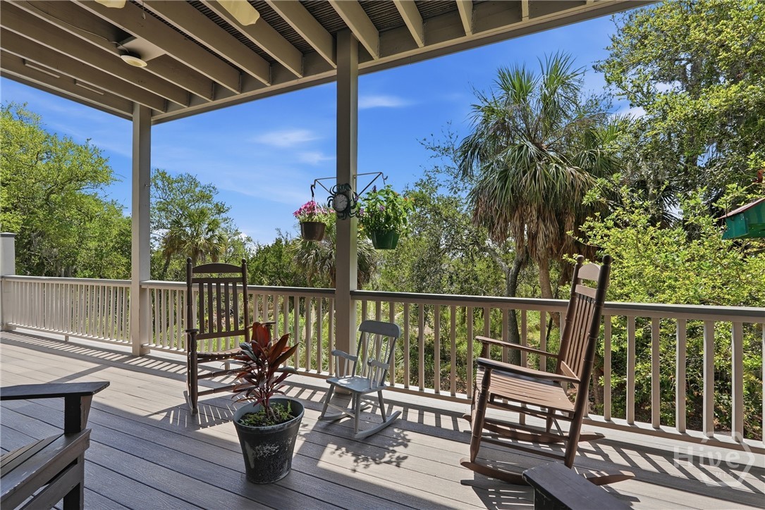 2nd floor covered porch with stairs down to backyard