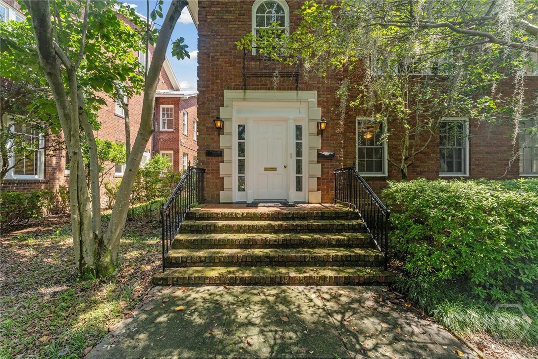 The front steps are flanked w/ cast-iron railings.