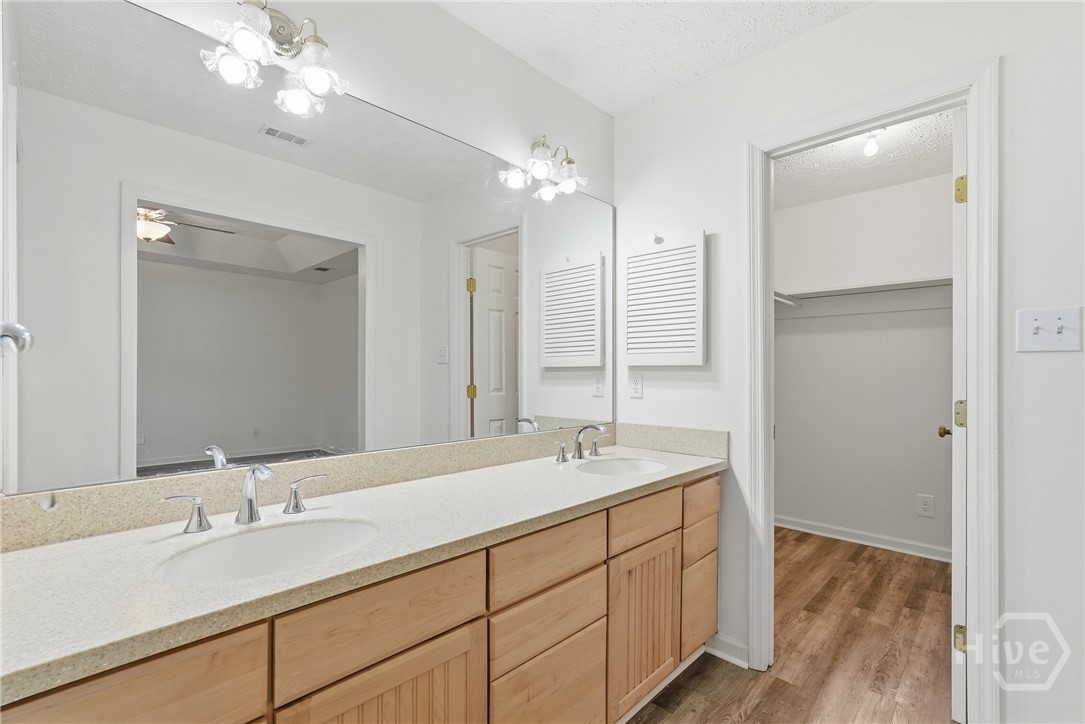Dual sinks with solid surface counters in the primary bedroom, plus walk in closet.
