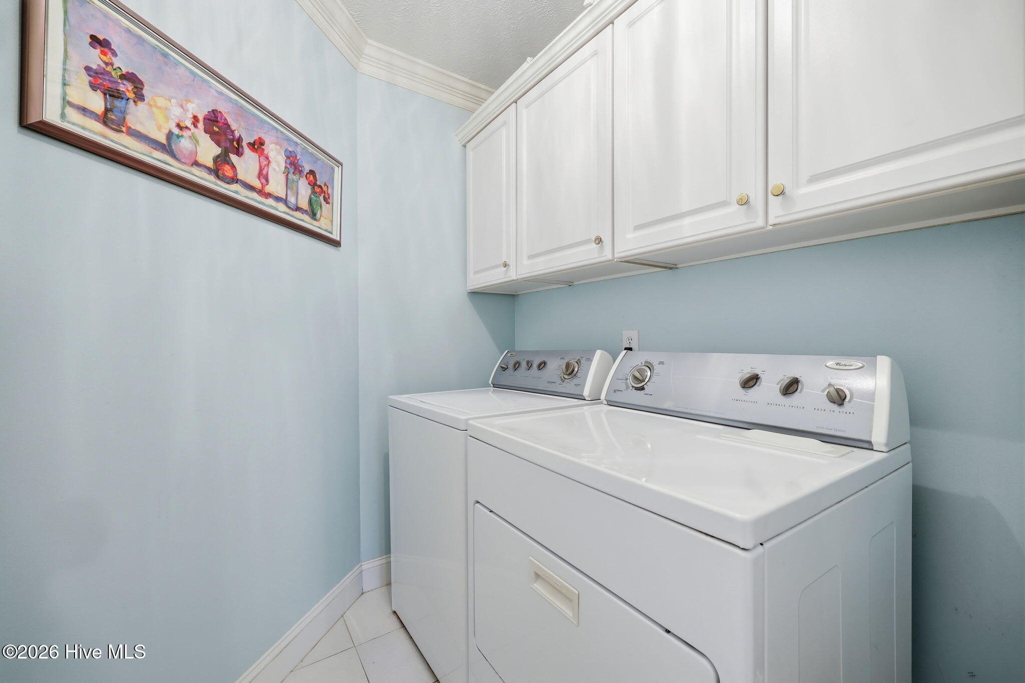 laudry room, tiled floro and storage cabinets