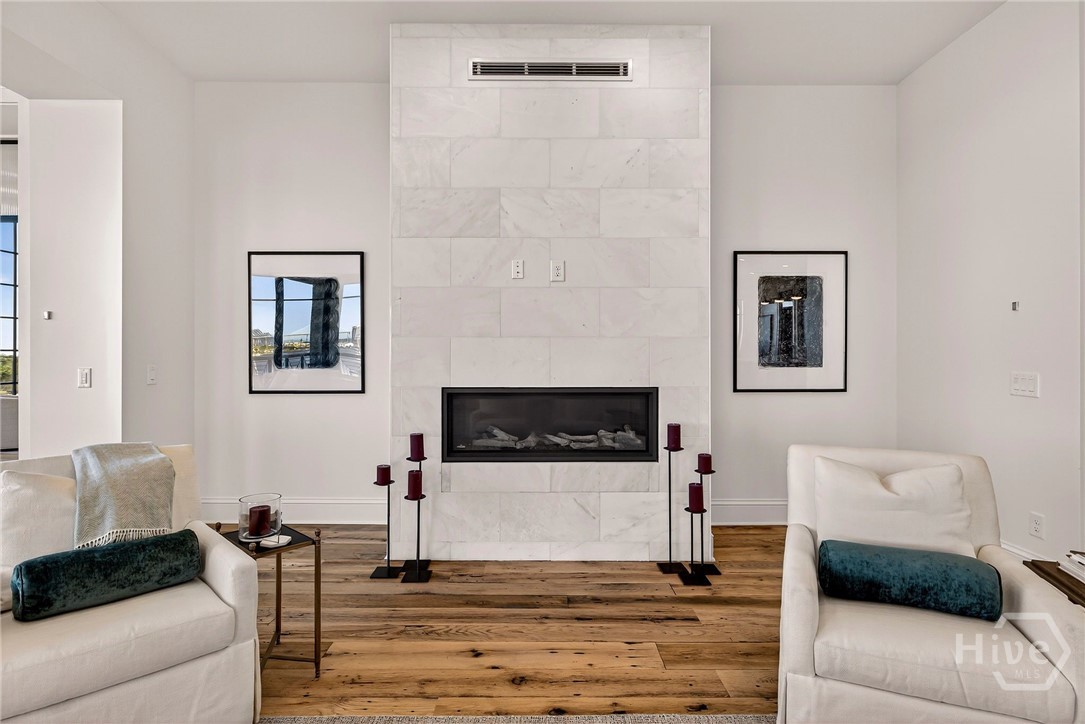 Living Room with a marble-clad fireplace anchors this intimate lounge enclave, offering symmetry and sophistication within the open-concept design. Strategically placed within the floorplan, it creates a quiet architectural moment while maintaining visual continuity. An ideal retreat for refined relaxation and elevated ambiance.