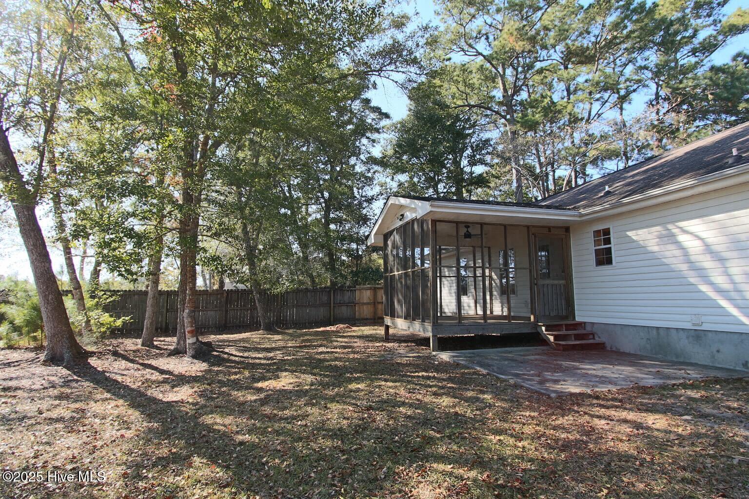 9117 Landing Drive SW, Calabash, NC 28467 – photo 7: Autumn Backyard with Porch and Trees