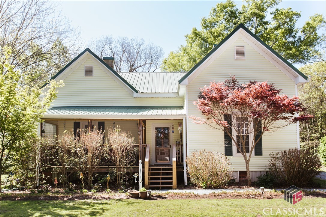 Gardener's Delight in Downtown Comer! 440 Laurel Avenue is a lovingly restored and updated cottage sited on half an acre bursting with various flowering perennials and trees. The main home features a screened-in front porch, original hardwood flooring, wide entry parlor room, original tongue-in-groove walls, and 12ft+ ceilings throughout. Owner's suite is sizable and includes a spacious ensuite bathroom with clawfoot tub, separate shower, double vanity, and walk-in closet. Two large, additional bedrooms share a hall bathroom. Living room features an original, now decorative fireplace as do the bedrooms. Cheery kitchen is complete with stainless steel appliances, large island, farm sink, and double window that overlooks the fenced yard. Just off the kitchen is the laundry room/ pantry and additional storage closet. There is a carport for covered parking as well as a detached garage with finished living space for potential rental income. The garage apartment features a full bathroom and kitchenette. Why did the chicken cross the road? To get to the chicken coop located on this beautiful property! Enjoy all seasons from the rear deck and watch the various flora change throughout the year. Many updates including double-pane windows, gutters, and metal roof.