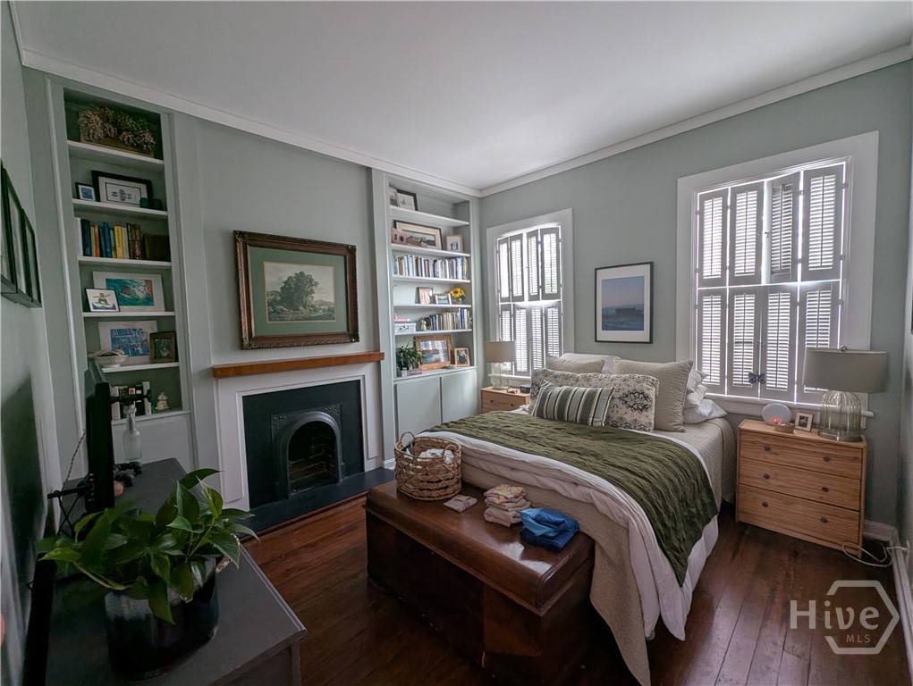 Primary bedroom with fireplace and built in shelving.