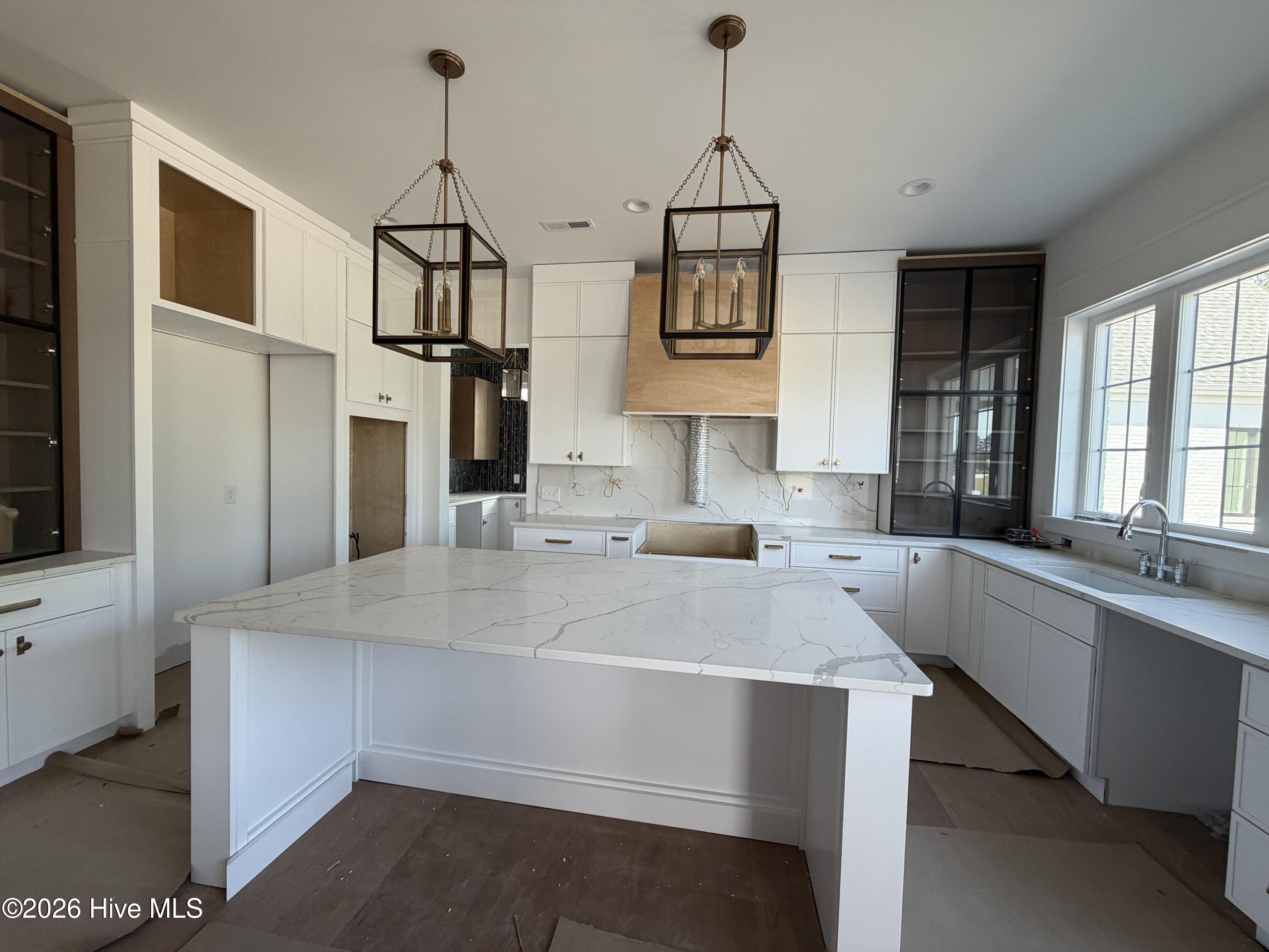 center island, and gold/black lanterns anchor this perfect kitchen