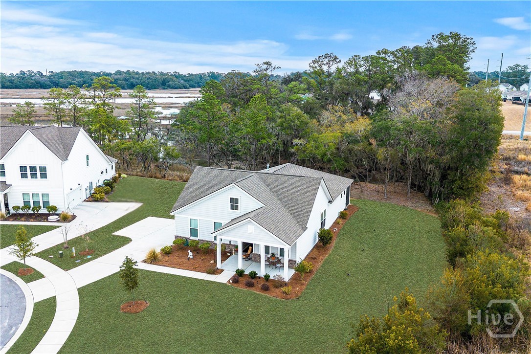 Situated on a private cul-de-sac lot, this home offers exceptional privacy backing to a scenic tidal creek with marsh views, bordered by a community green space creating a natural buffer. Sunrise views from the oversized screened back porch overlook the water in a peaceful waterfront setting framed by mature live oaks draped in Spanish moss. An extended driveway provides ample parking and leads to a side-entry two-car garage. Inside, the open-concept floor plan living area features a gas fireplace and seamless flow to the gourmet kitchen, which includes a gas cooktop, built-in double ovens, quartz countertops, soft-close cabinetry, large pantry, and under-cabinet lighting. The spacious primary suite offers two walk-in closets and a private en-suite bath with dual vanities, soaking tub, and separate tiled shower. The second bedroom includes its own en suite bathroom and walk-in closet, and the third room provides versatile flex space ideal as a bedroom, home office, or study. Residents enjoy access to community amenities including a resort-style pool, walking and nature trails, outdoor fire pit, pickleball courts, and a waterfront community dock with water access, offering both recreation and connection to the Lowcountry lifestyle.