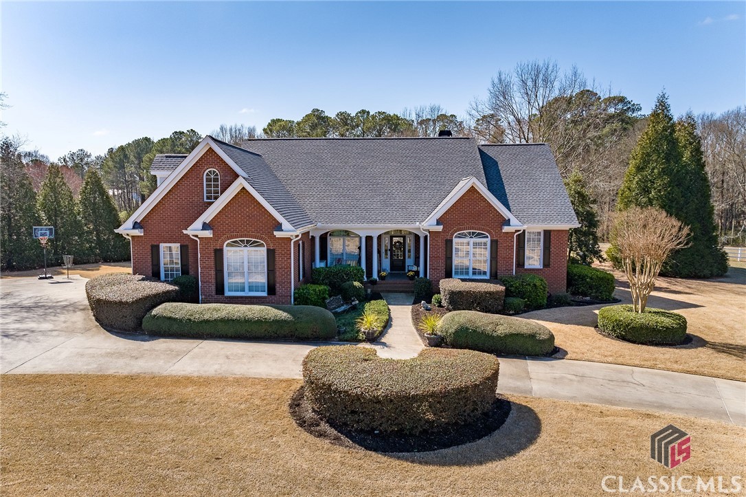 Welcome to 155 Sagewood Drive in charming Winterville. This two-acre mini-farm provides access to a unique way of life, surrounded by 18 acres of communal equestrian facilities. The property is a haven for those who cherish the pastoral life, featuring two barns with tack rooms, utilities, hot wire fencing, round pens, and trails. Though not mandatory, the community is exceptionally welcoming to horses, making it a perfect place for animal lovers.+++The home itself is a ranch-style residence designed with elegance and comfort in mind. It offers a functional split bedroom plan with two bedrooms on each side of the central living spaces, ensuring privacy, plus an additional bedroom upstairs.+++The great room, combined with the dining area, is filled with natural light from windows and french doors that lead to a screened porch overlooking the pastures. A cozy fireplace with a slate surround and built-in bookcases serves as a warm focal point. The owner’s suite is a private retreat with hardwood floors, a trey ceiling, and a renovated en-suite bath featuring dual vanities, a new large shower & flooring, and a tub.+++Designed for seamless flow, the home features wide doorways throughout. Additional bedrooms and a bath on one wing are ideal for guests while the upper level hosts a spacious fifth bedroom with ample storage space.+++The kitchen and breakfast area boast vaulted beamed ceilings, quartz countertops, and a picturesque view of the pasture, meeting practical daily needs with a laundry room and built-in cabinets just off the garage.+++Upgrades to the property include a newer roof and HVAC, brand new owner’s shower, efficient insulation, an irrigation system, a double septic system, and a circular driveway. Details extend to real oil-rubbed bronze hardware and ADA compliant toilets. Exterior features include hardie board soffit and fascia, and a yard landscaped with Bermuda grass, enhancing the property's appeal.+++155 Sagewood Drive is more than just a residence; it's a place where rustic allure and current conveniences come together, offering a lifestyle that's both serene and well-suited for today's living.+++Winterville is a vibrant municipality of Athens about six miles to UGA with an art’s council, a (new) cultural center, a marigold festival in May at Pittard Park, and home to beloved Little City Diner.