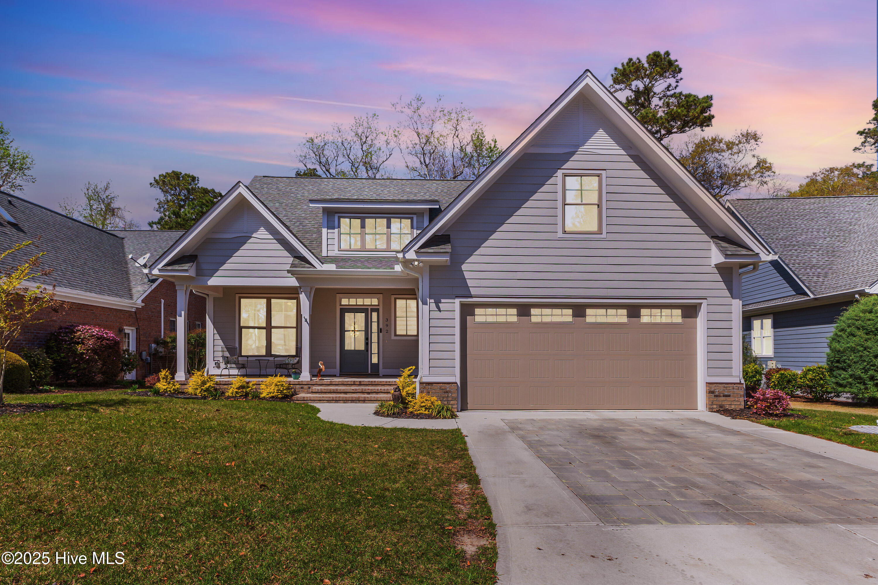A fresh take on coastal living—this home offers a quieter, more refined interpretation of the classic design. It's where soft sand tones meet rich wood textures, and light pours in like salt air through every window.Set within Winding River Plantation, this nearly new home brings modern ease to a timeless setting. Blonde engineered hardwood floors stretch across the main living space, echoing the natural tones of driftwood and dunes. The walls, painted a gentle sand, feel warm and sun-washed. In the kitchen, two-tone cabinetry continues the story—creamy uppers and wood-grain base cabinets that feel rooted and earthy. A bold black hood punctuates the space, pulling the whole look together with style and intention.In the great room, vaulted ceilings and a native driftwood mantel over the electric fireplace create a pretty backdrop for everyday living. Step outside to the covered porch, where views of the lush green woods offer privacy and calm.The primary suite feels like a true retreat, wrapped in soft greys and featuring a tray ceiling that adds quiet sophistication. Wake to leafy views and step straight onto the porch with your morning coffee. The en-suite bath is resort-worthy, with his-and-hers closets and a walk-in shower with dual showerheads—perfect for a slow start or a post-beach rinse.A second bedroom sits just off the foyer behind frosted-glass sliding doors—ideal for guests or a sunlit workspace. Upstairs, a third bedroom, full bath, and generous flex space offer even more room to stretch out.But the lifestyle here extends far beyond your front door. Winding River Plantation is one of the area's most coveted communities, with amenities that read like a vacation itinerary: a private beach club on Holden Beach, two marinas, a 27-hole Fred Couples-designed golf course, a fitness center, pickleball courts, walking trails, and a sparkling resort-style pool.If you've been looking for something that feels fresh & grounded - this is it.